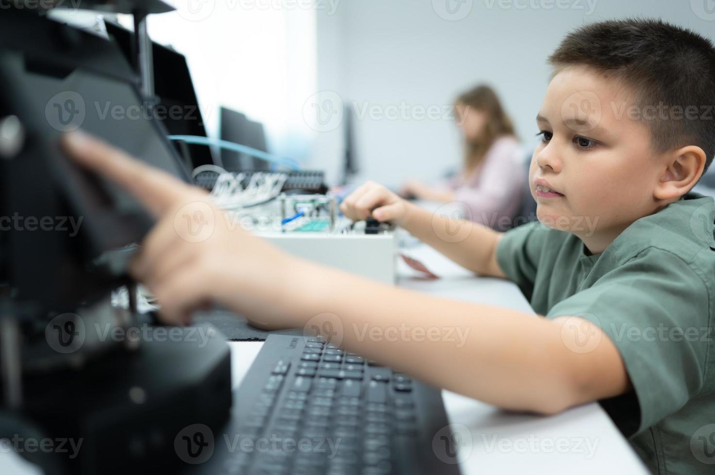Youngsters utilizing the hand robot technology are having fun learning the electronic circuit board and hand robot controller of robot technology, which is one of the STEM courses. photo