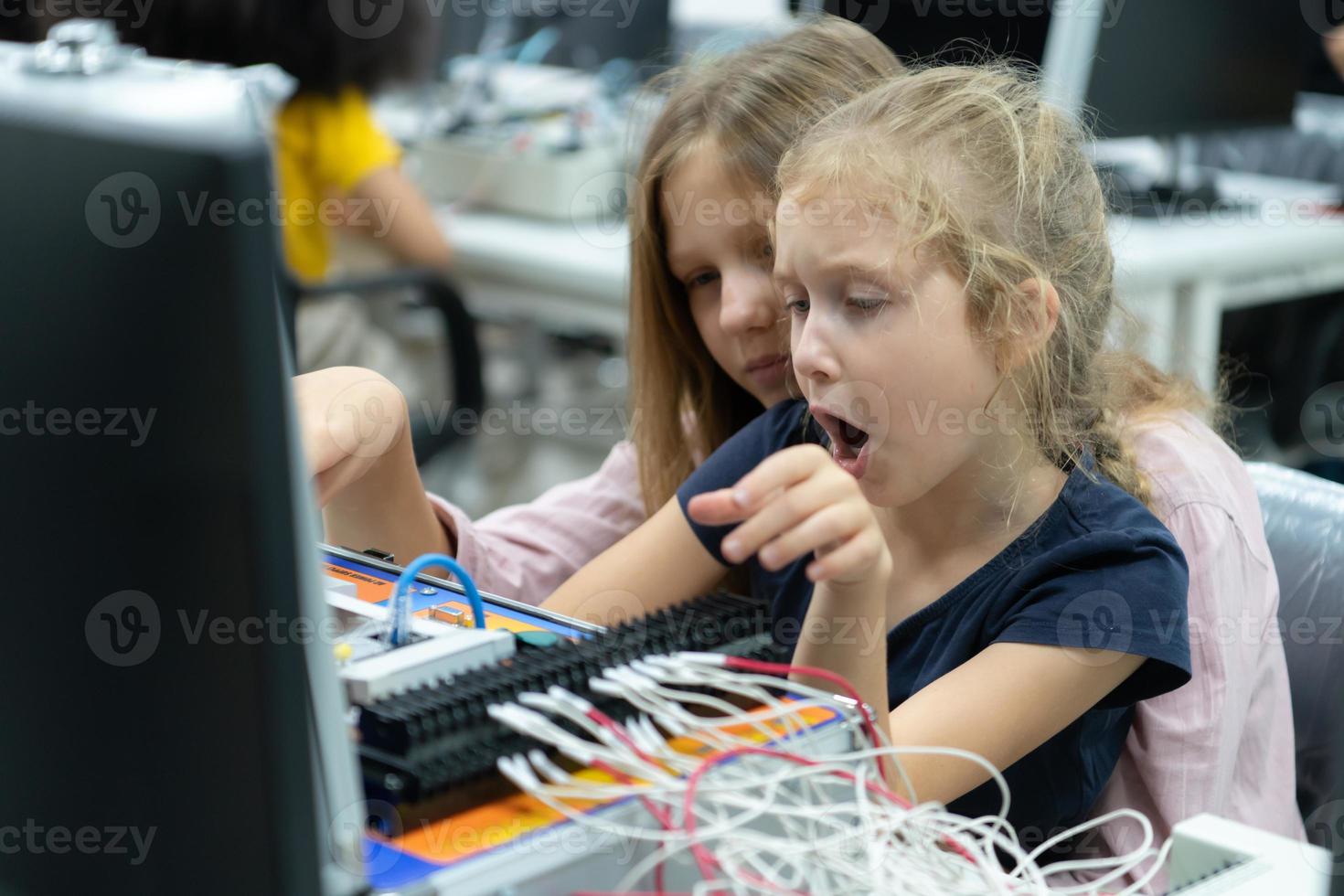 Children using the hand robot technology and having fun Learning the electronic circuit board of hand robot technology, which is one of the STEM courses. photo