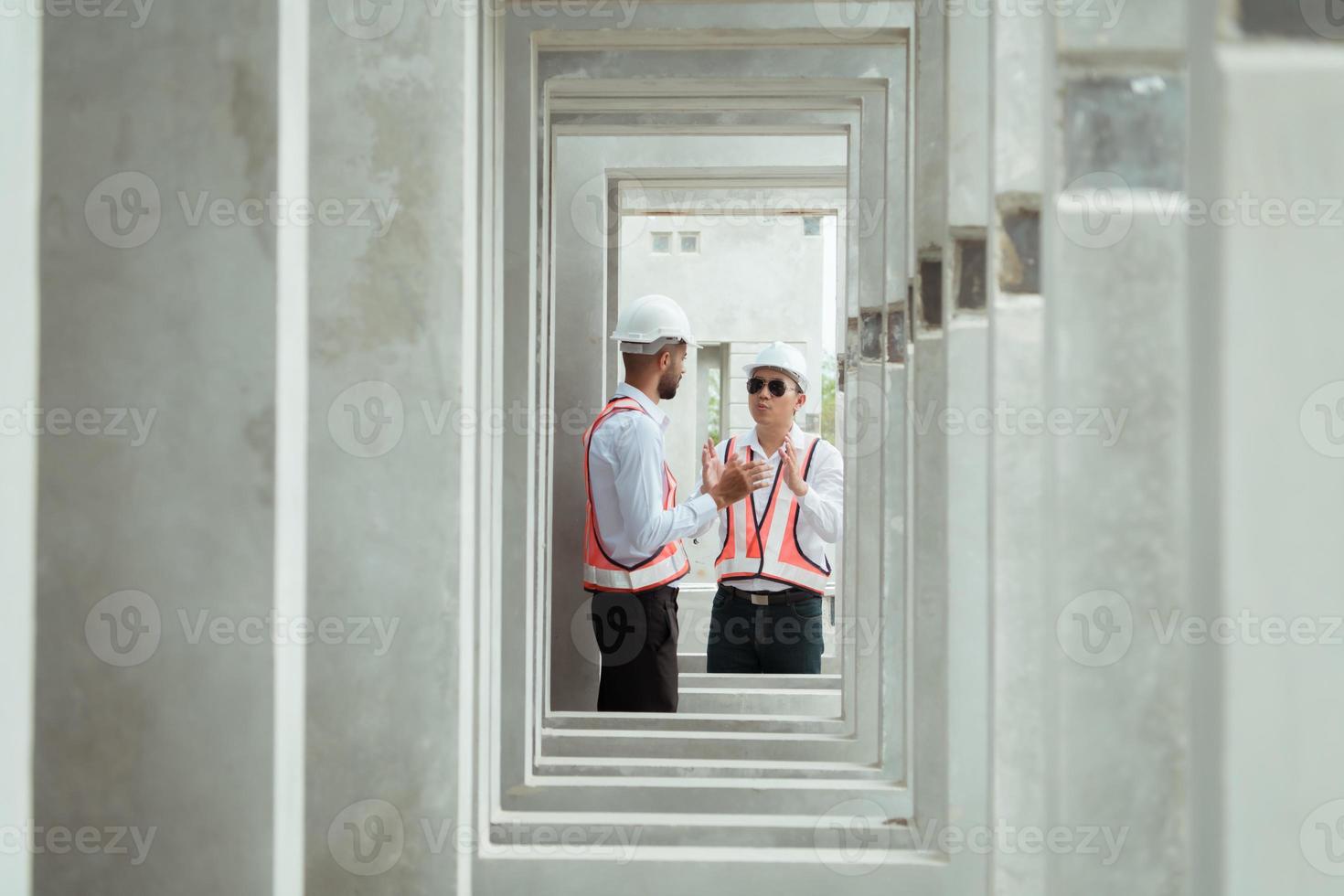 Both of construction engineers verify the constructed precast concrete wall slabs' quality. also to oversee significant construction projects in the construction zone photo