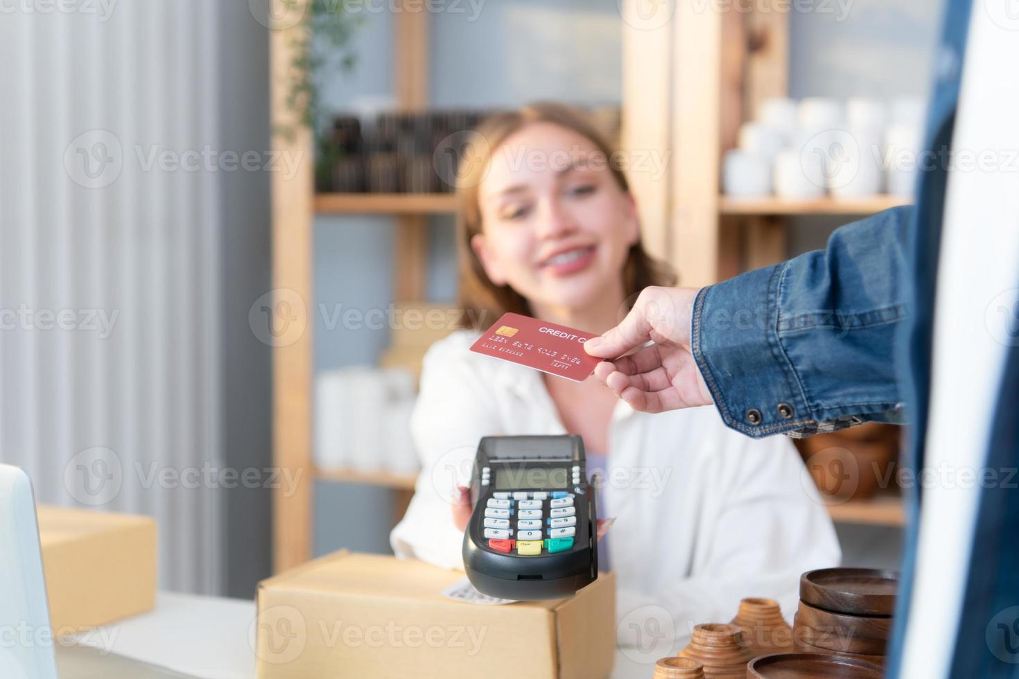 joven mujer pequeño negocio propietario con un crédito tarjeta pago sistema foto