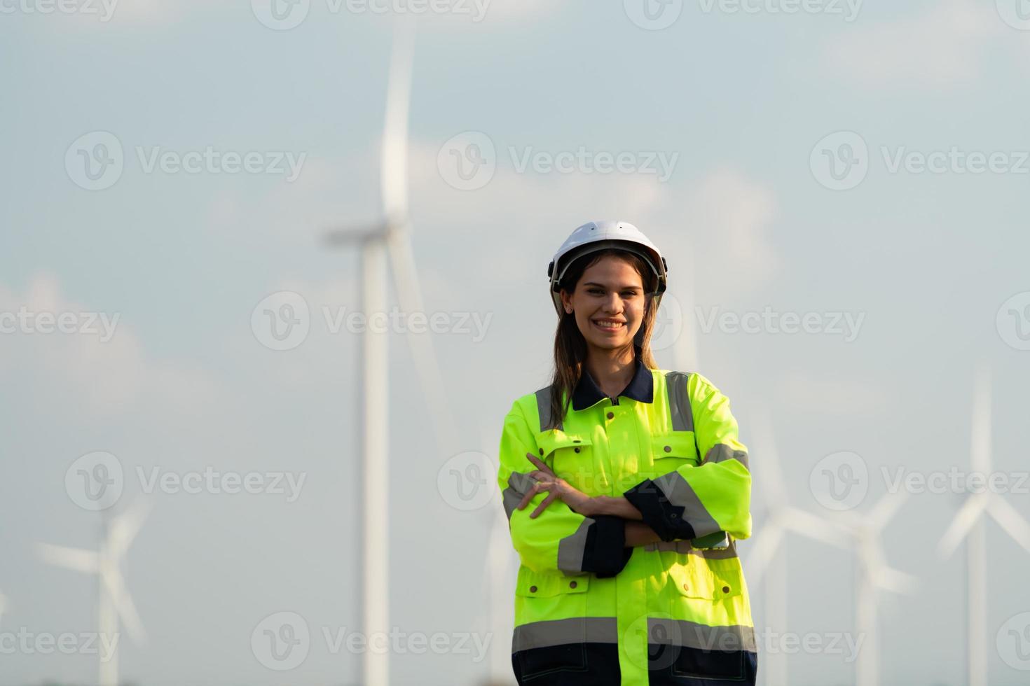 retrato de hembra ingeniero a natural energía viento turbina sitio con el misión de siendo responsable para tomando cuidado de grande viento turbinas foto