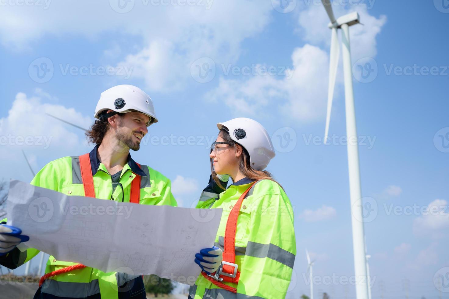 Man and female engineer stationed at the Natural Energy Wind Turbine site. with daily audit tasks of major wind turbine operations that transform wind energy into electrical electricity photo