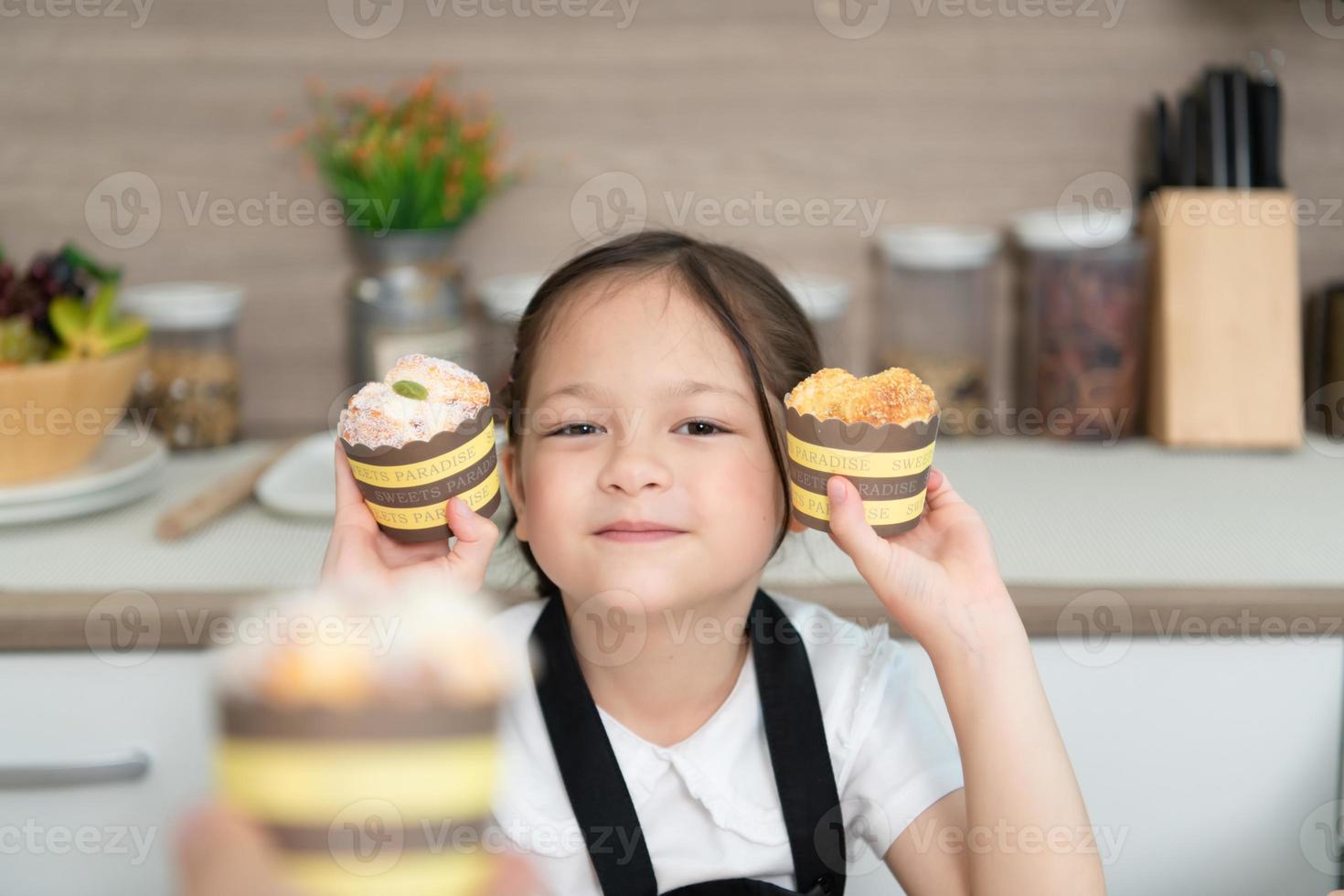 Portrait of a little girl in the kitchen of a house having fun playing baking bread photo