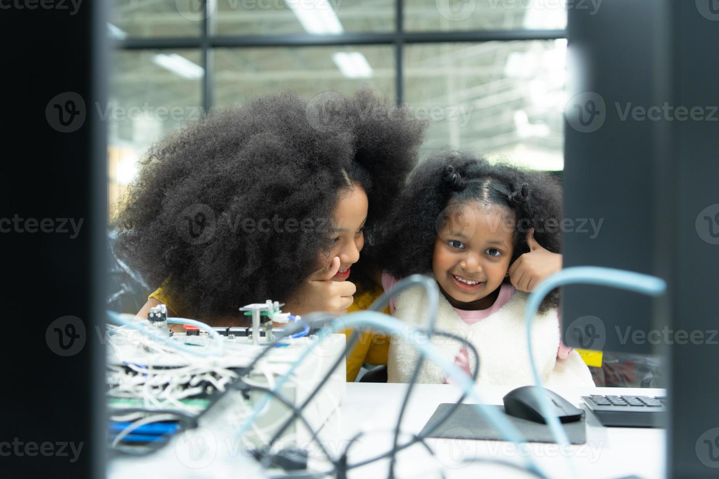 Children using the hand robot technology and having fun Learning the electronic circuit board of hand robot technology, which is one of the STEM courses. photo