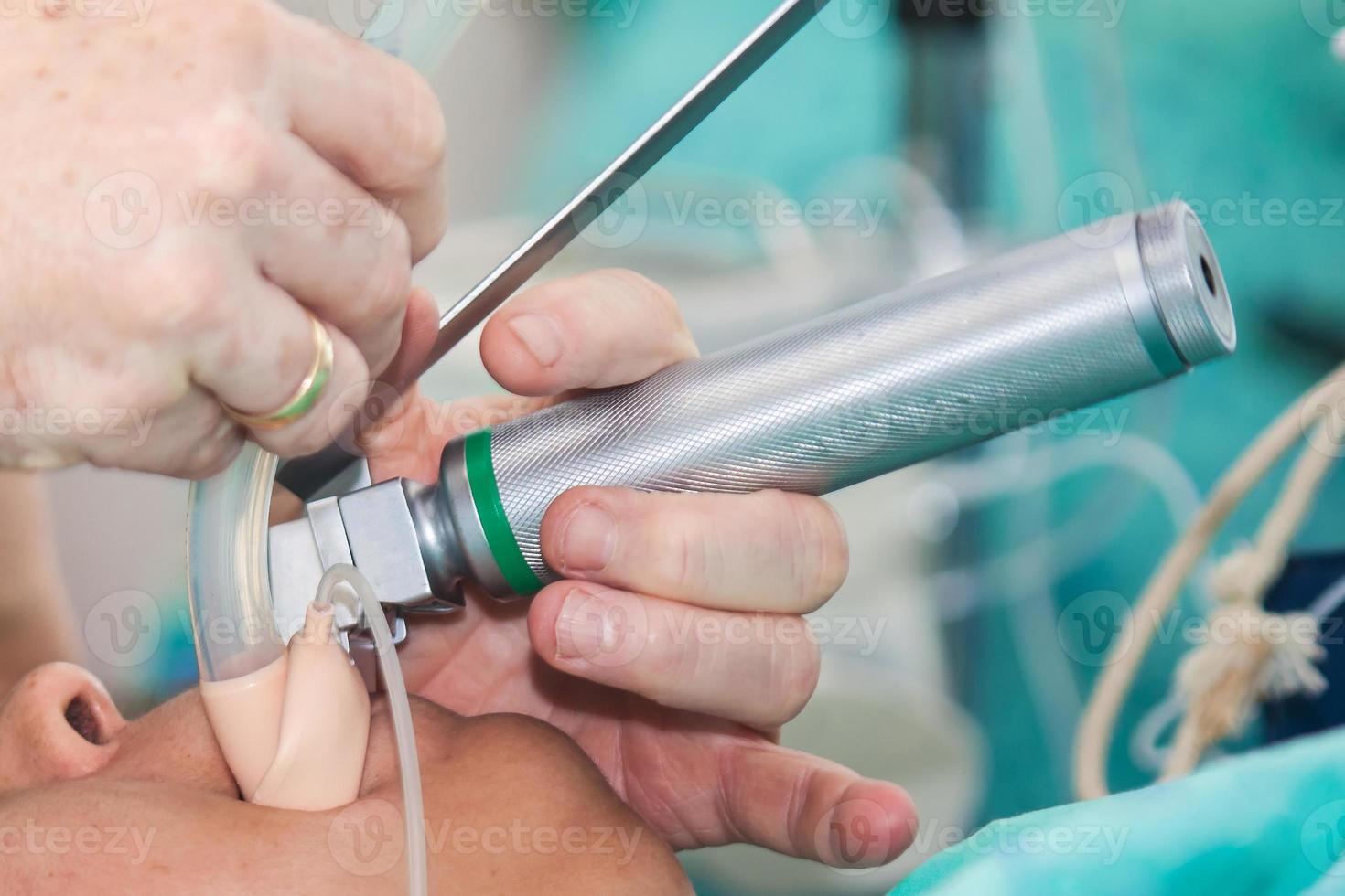 Anesthesiologist performing an endotracheal intubation to a female patient at the beginning of a surgery photo