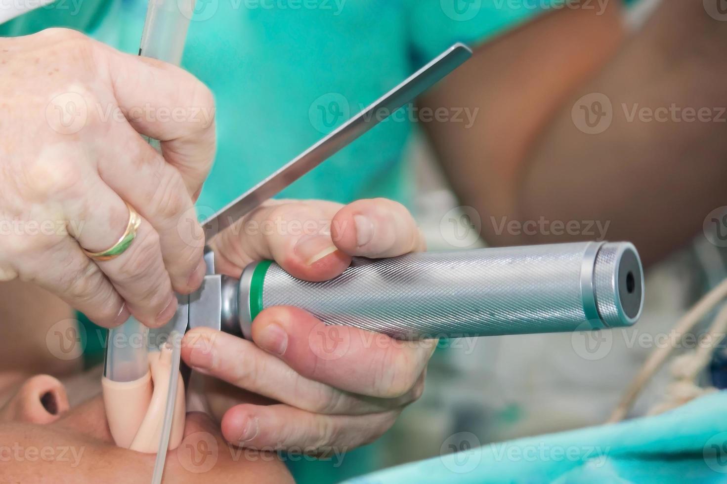 Anesthesiologist performing an endotracheal intubation to a female patient at the beginning of a surgery photo
