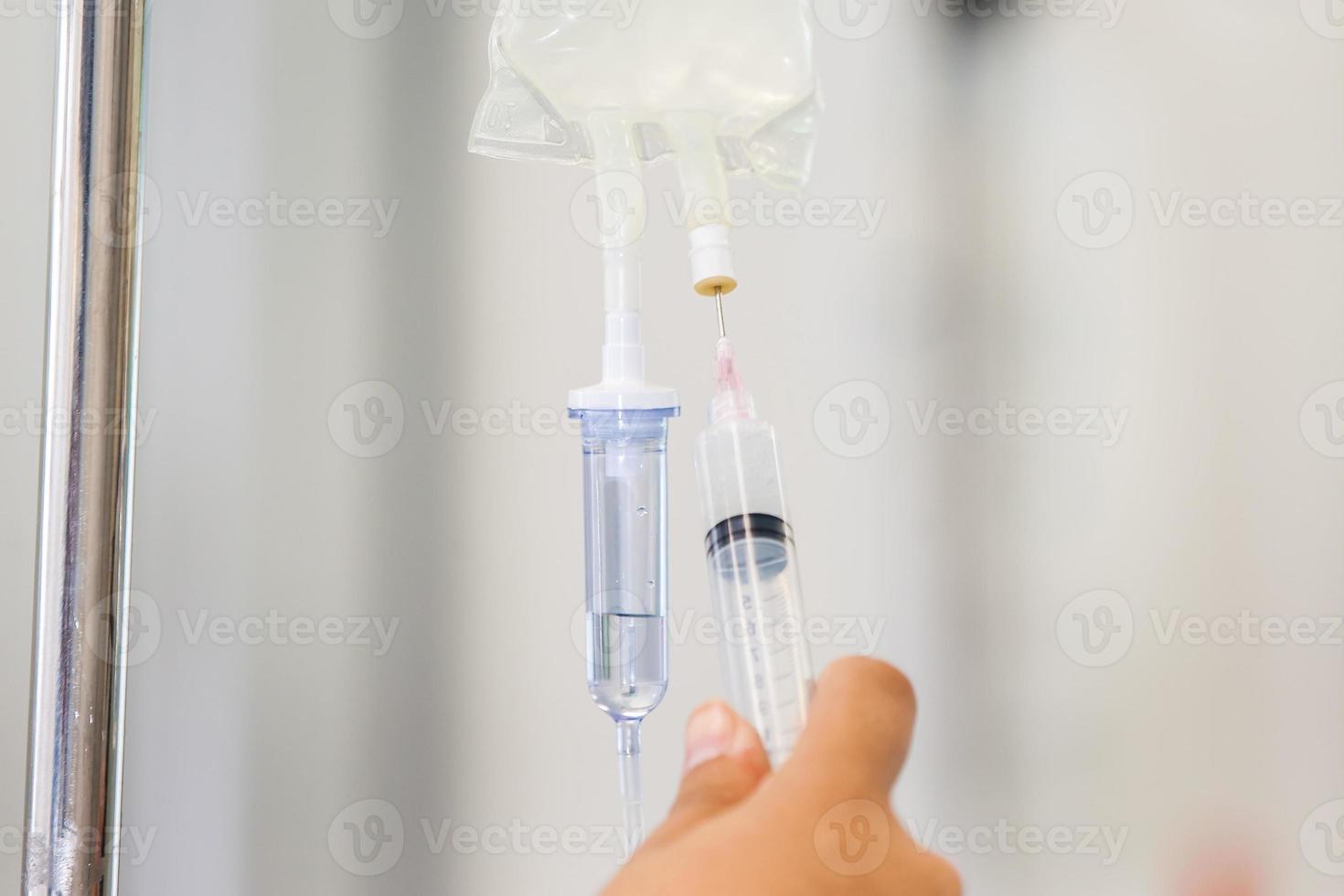 Nurse injecting a drug through an infusion system photo