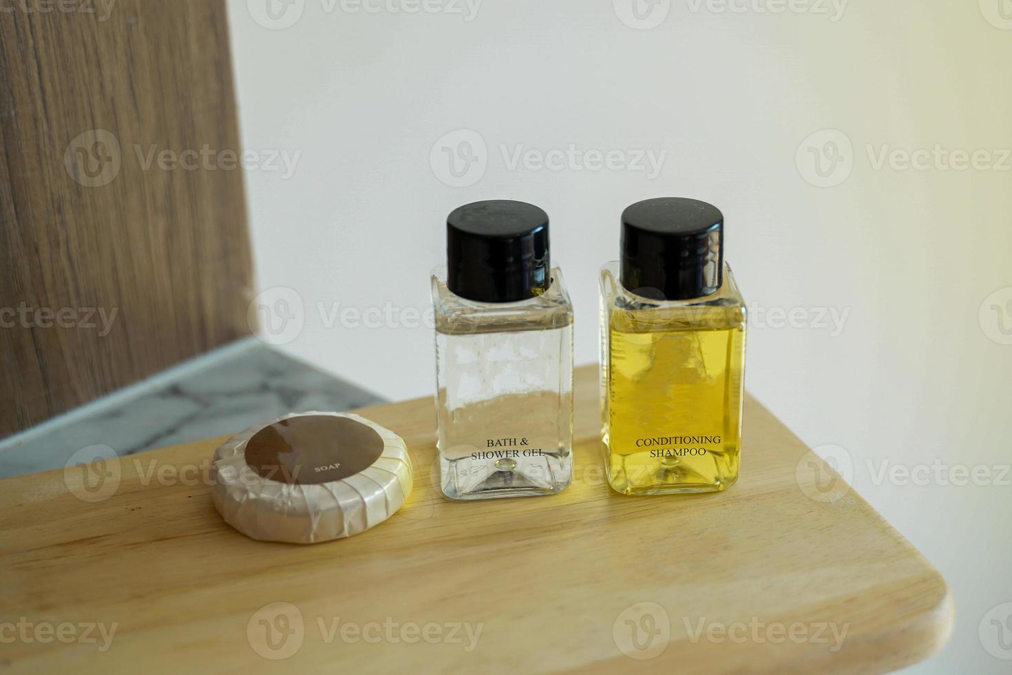 The bath set is placed on the wooden planks that the hotel provides to guests for free. There are soap, liquid soap, shampoo, conditioner. Soft and selective focus. photo