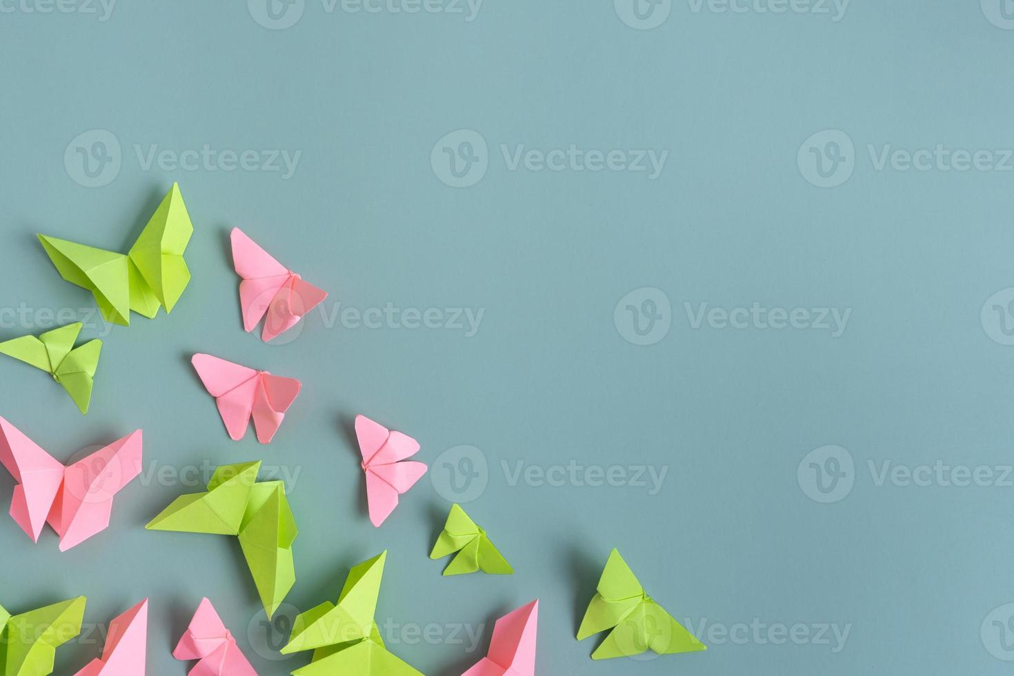 Paper butterfies green and pink color flat lay on a colored background. Lightness, spring beauty concept photo
