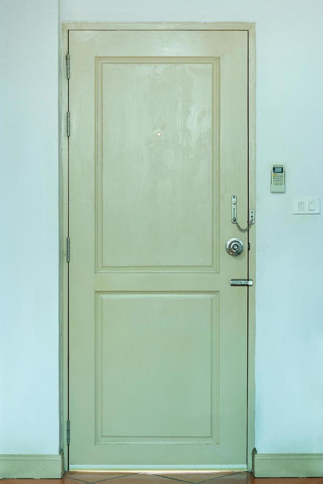 Wooden Door with Light Switch and Air Conditioner Remote in the Room photo