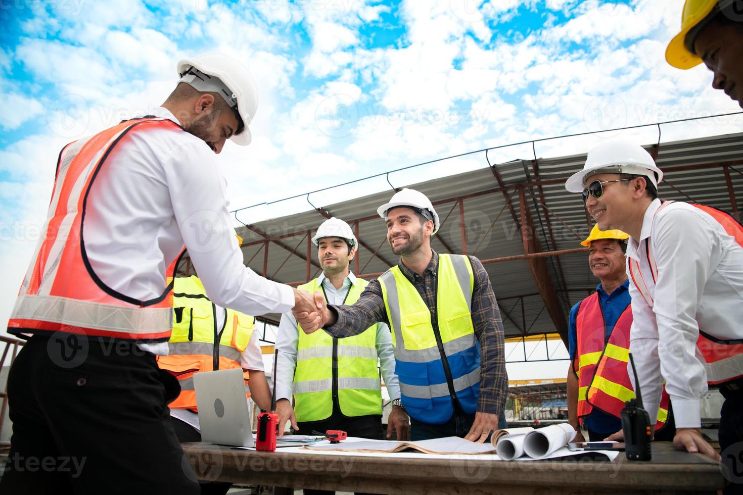 Construction engineers, architects, and foremen form a group. Participate in a meeting to plan new construction projects. Shake hands in thanks for the successful completion of the responsible work. photo