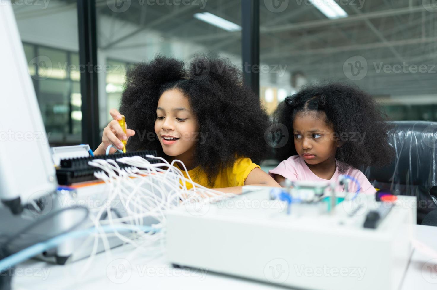 Children using the hand robot technology and having fun Learning the electronic circuit board of hand robot technology, which is one of the STEM courses. photo