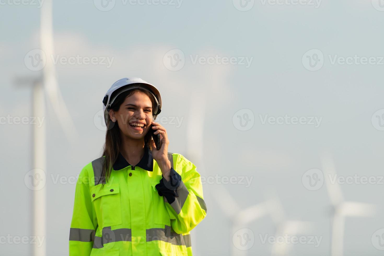 hembra ingeniero a natural energía viento turbina sitio con el misión de siendo responsable para tomando cuidado de grande viento turbinas utilizar el teléfono a comunicar con tu familia a obtener eliminar de desaparecido usted foto