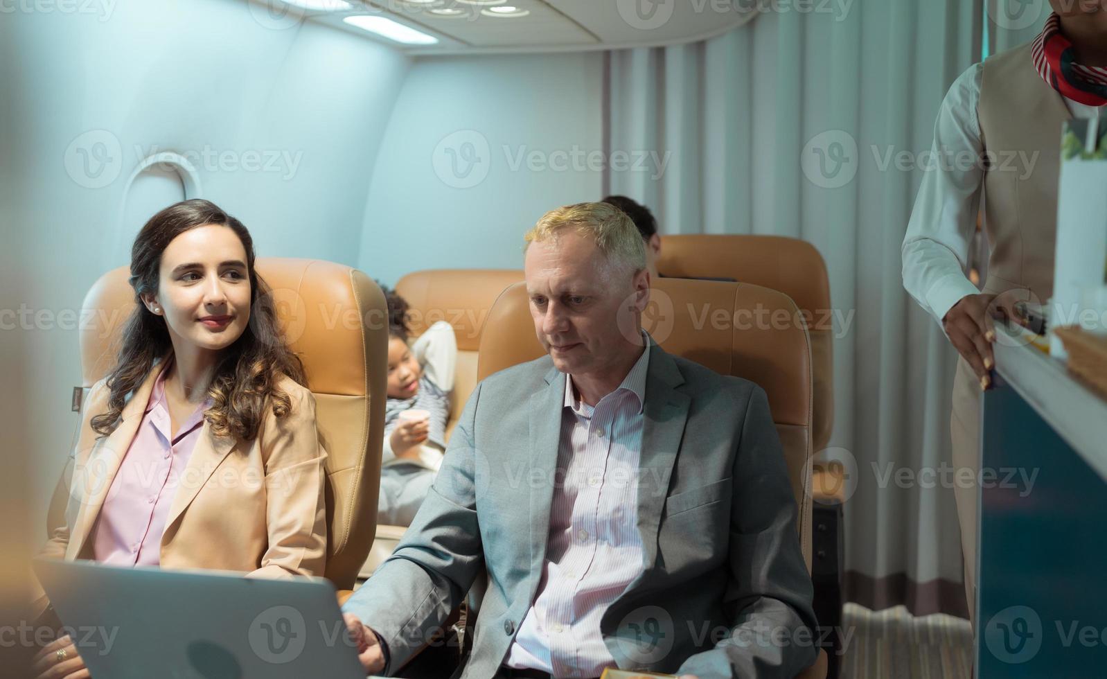 Flight attendant serving food and drinks to passengers photo