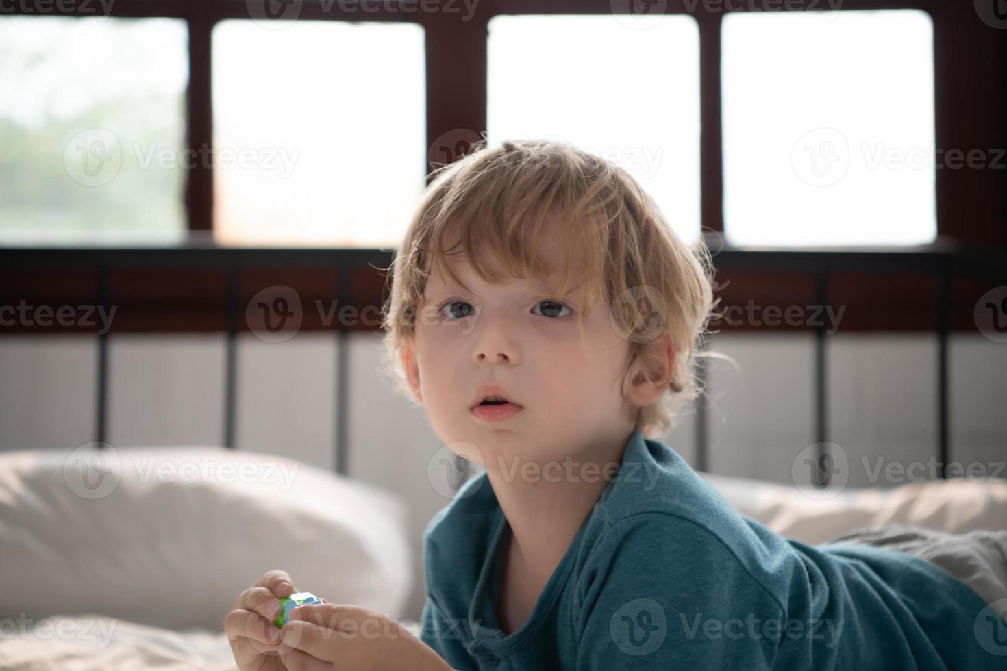 Little boy in his bedroom with a new toy purchased by his parents to help him improve his thinking skills. photo