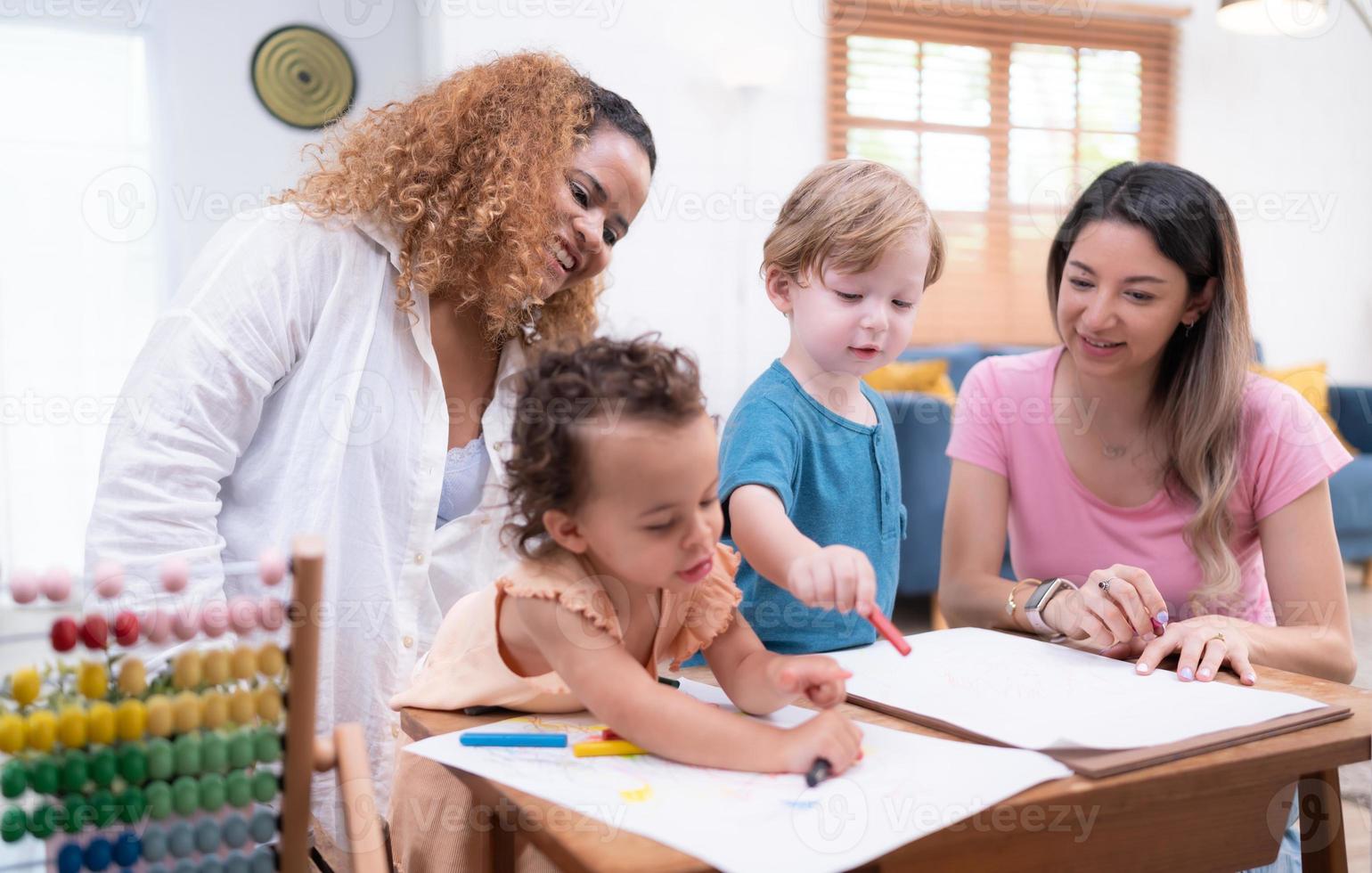 un pequeño niño imaginación es representado mediante de colores lápiz dibujos, con el madre atentamente supervisando en el vivo habitación de el casa. foto