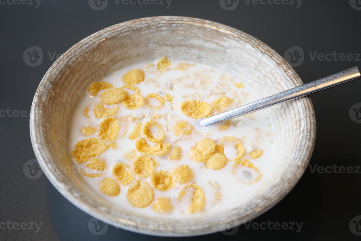 corn flakes cereal with milk on table photo