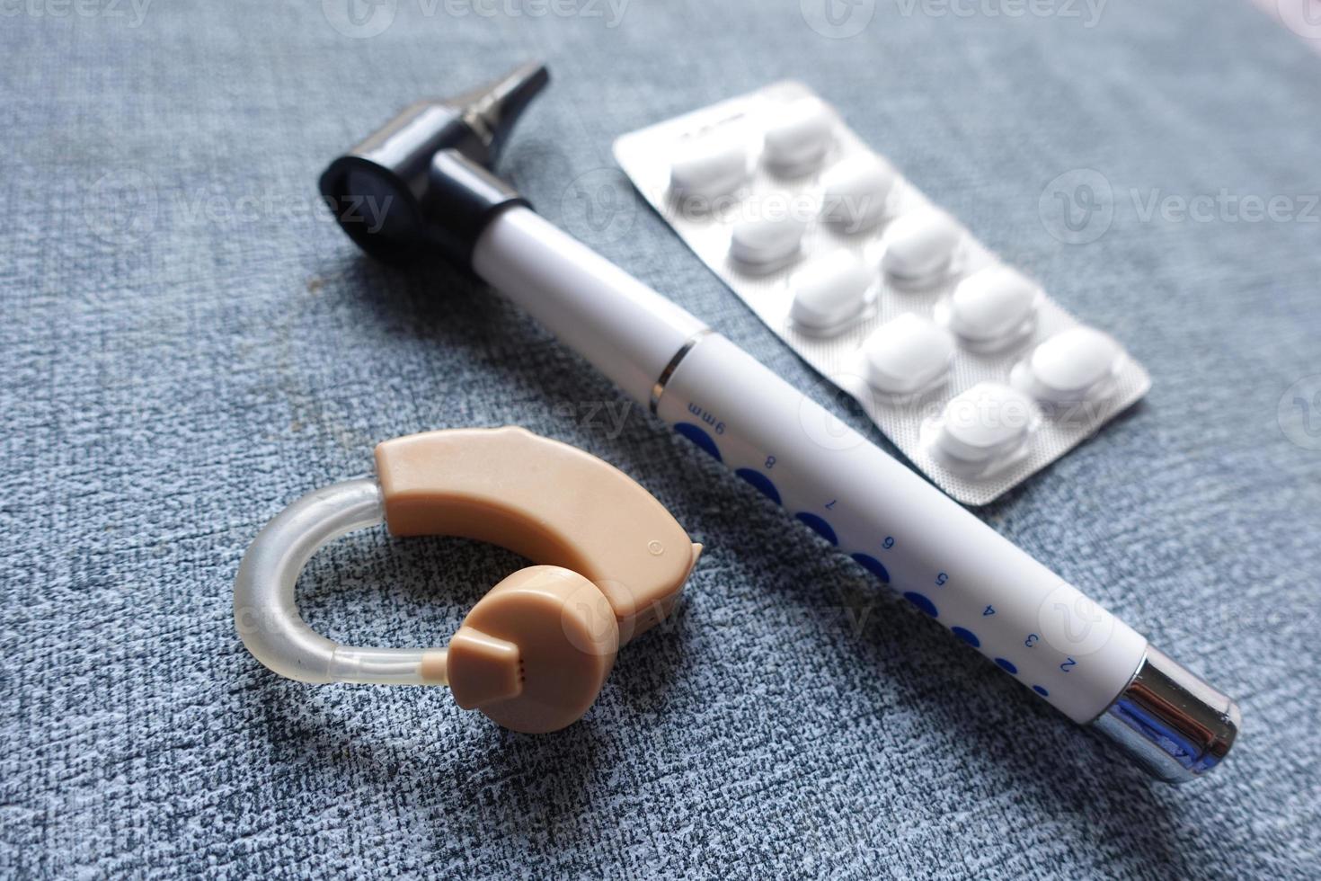 Hearing aid equipment and medical pills on table close up photo