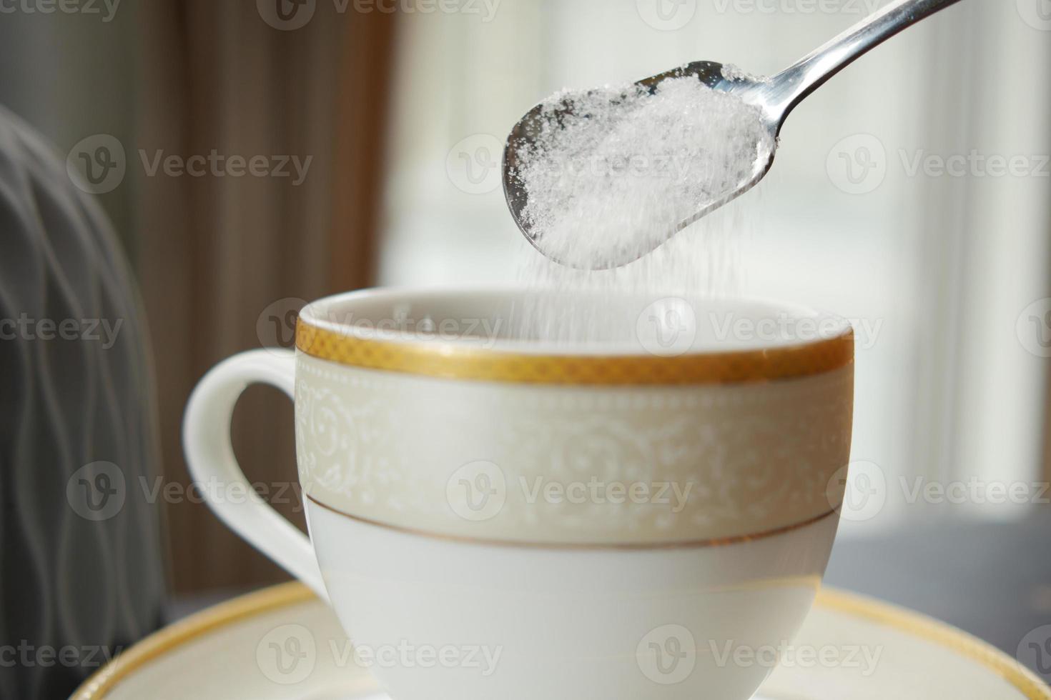 pouring white sugar in a coffee cup , photo