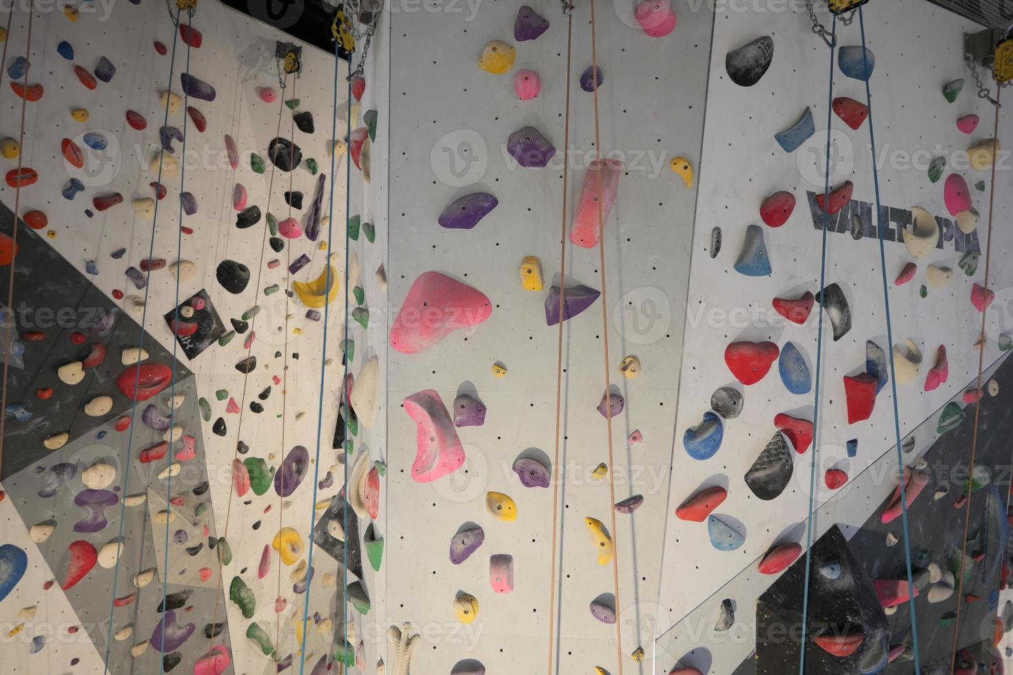 Artificial climbing wall with Colourful grip rocks. photo