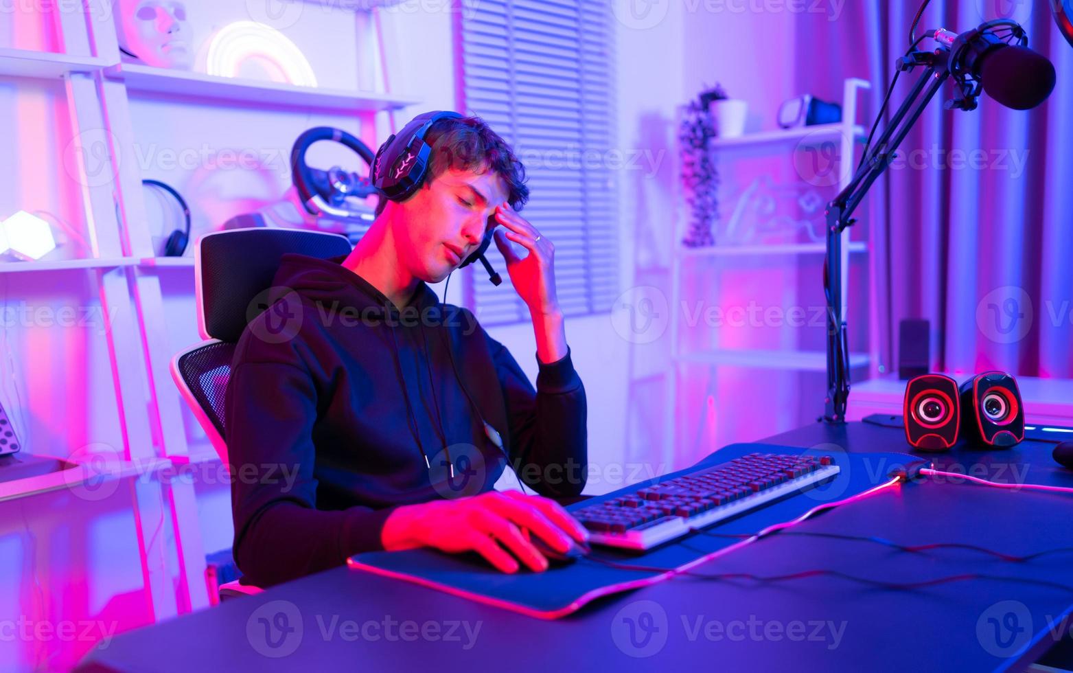 Gamer holding his head with both hands and having a frustrated mood unpleasant when playing a game losing to an opponent photo