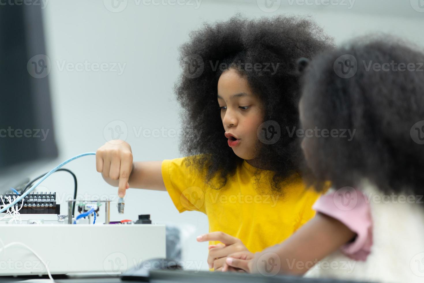 Children using the hand robot technology and having fun Learning the electronic circuit board of hand robot technology, which is one of the STEM courses. photo