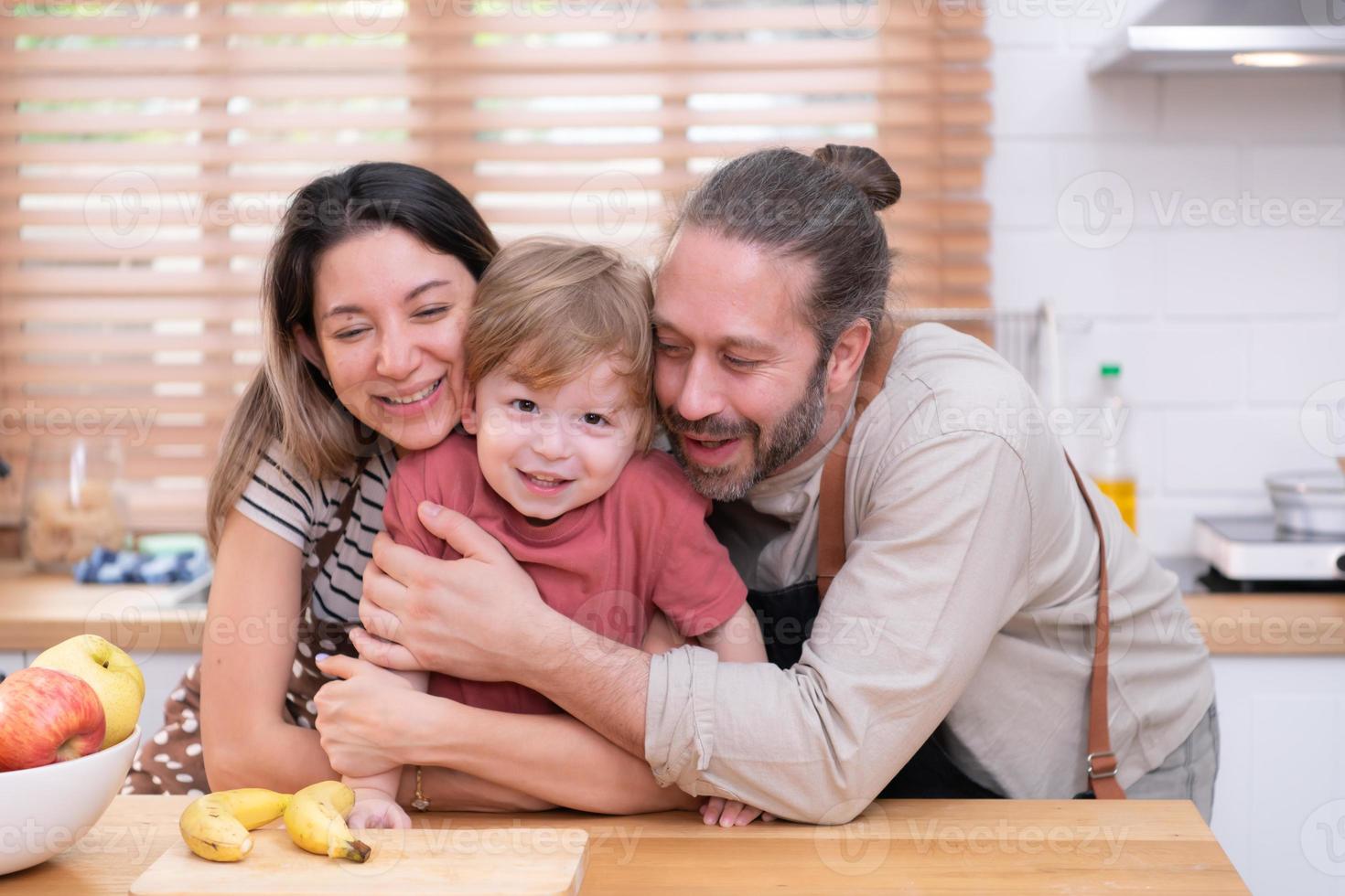 mamá y papá en el cocina de el casa con su pequeño niños. tener un bueno hora haciendo cena juntos. foto