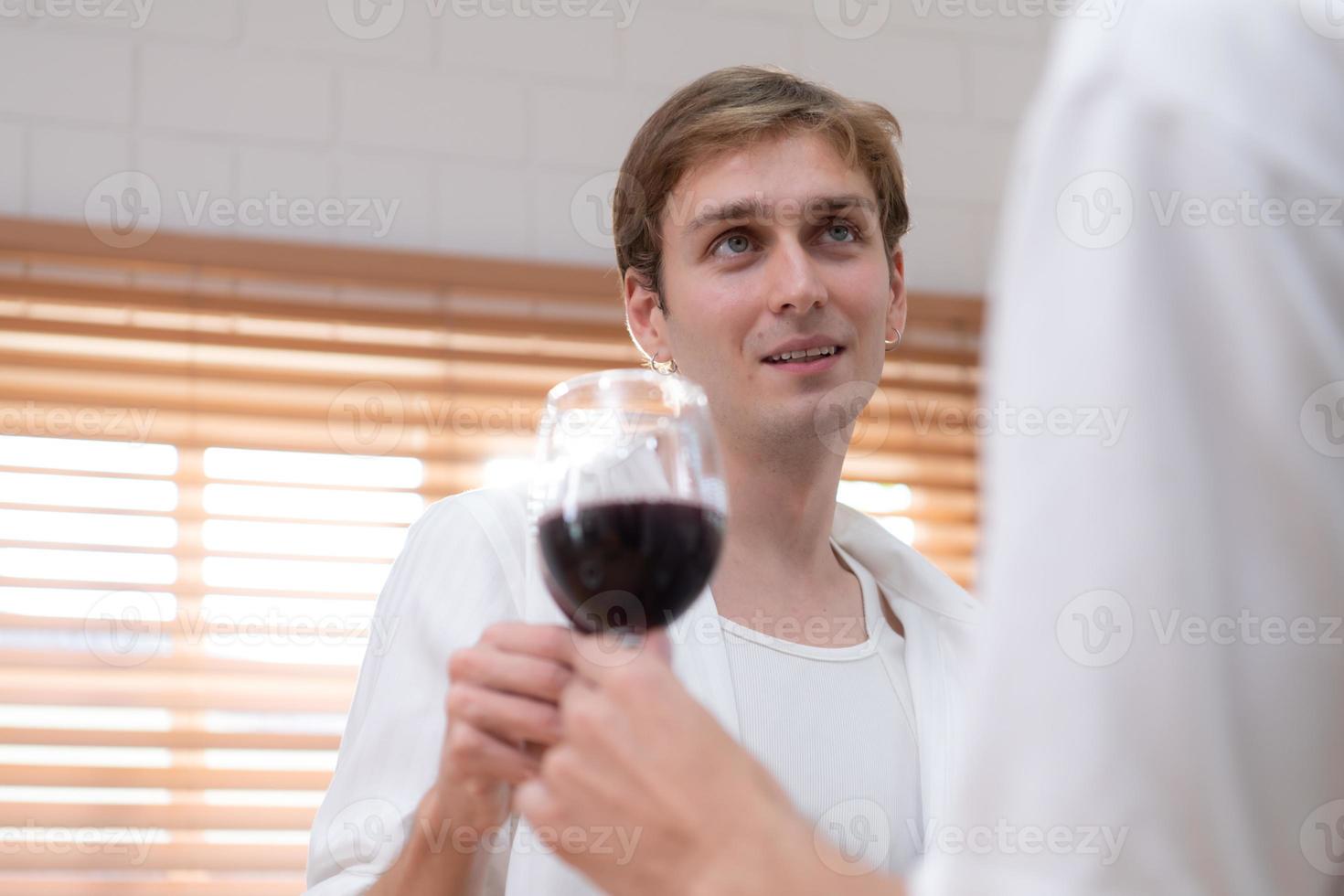 LGBT Young couple celebrate the day of love between each other with fine wine in the kitchen of the house photo