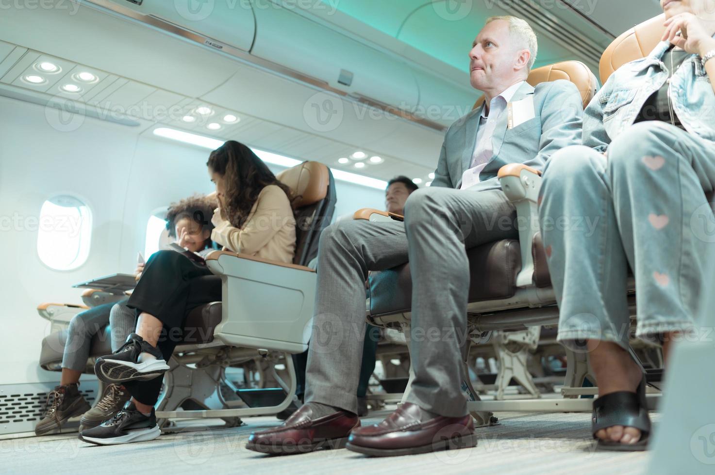Passengers listen to flight attendants demonstrate how to use safety equipment. photo