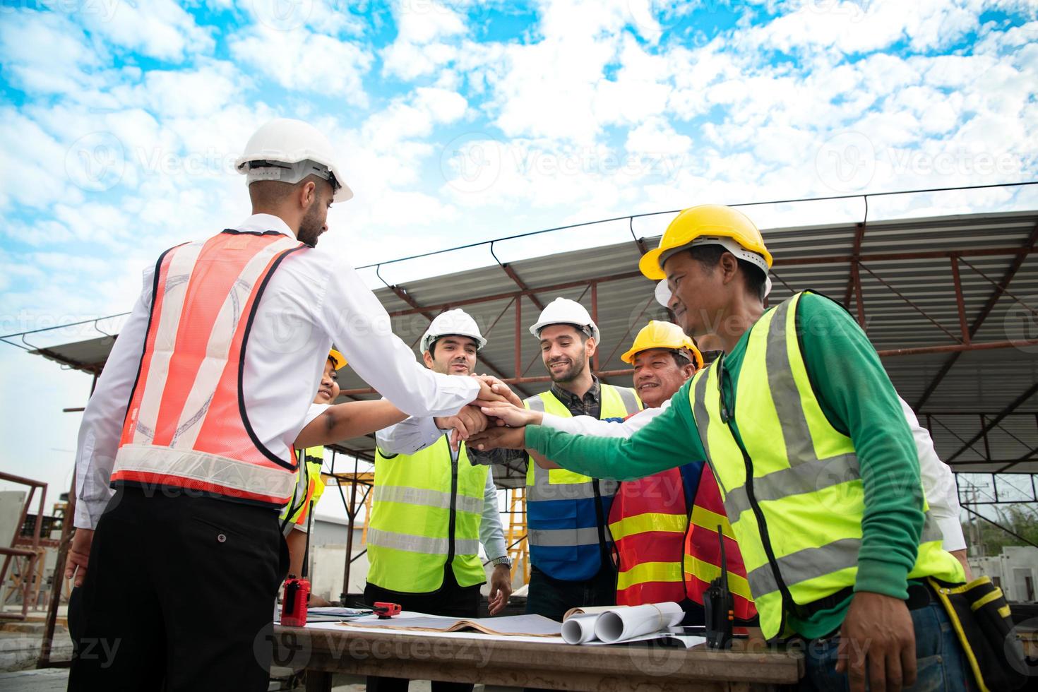 Construction engineers, architects, and foremen form a group. Participate in a meeting to plan new construction projects. Cheers to express happiness that the event was successfully accomplished. photo