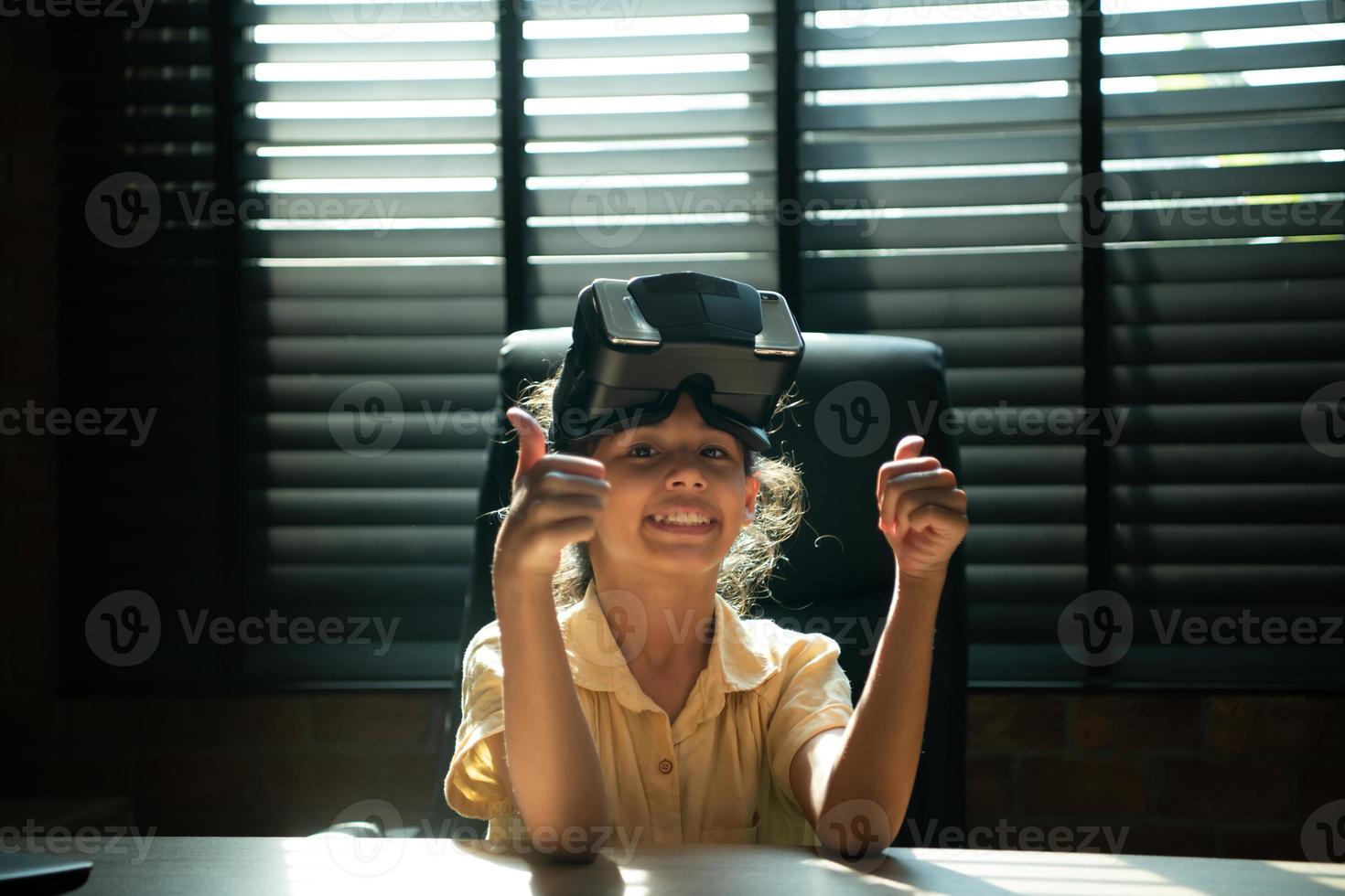 Portrait of little girl in office room of house with gestures that are expressed when playing virtual reality games photo