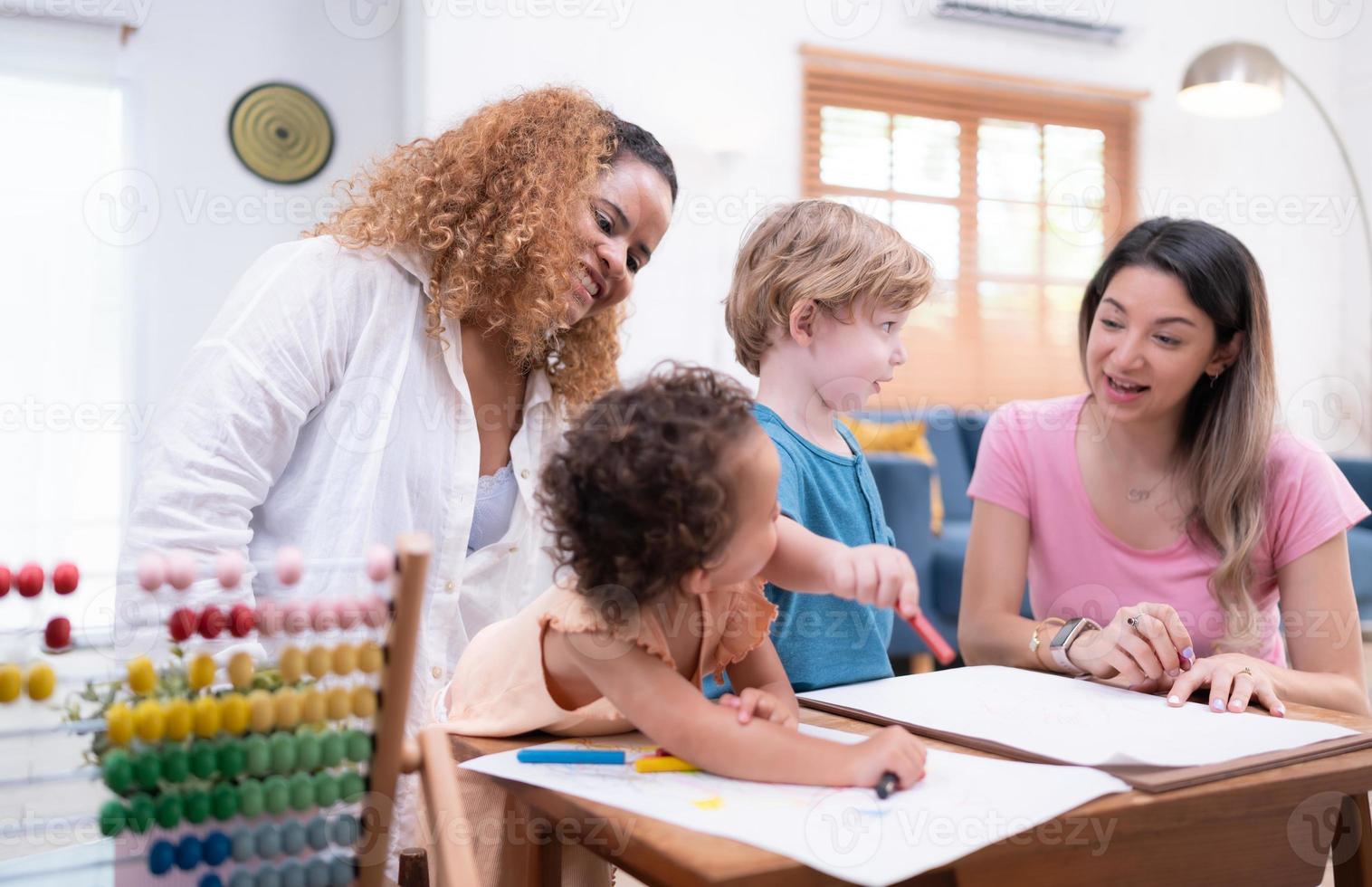 un pequeño niño imaginación es representado mediante de colores lápiz dibujos, con el madre atentamente supervisando en el vivo habitación de el casa. foto