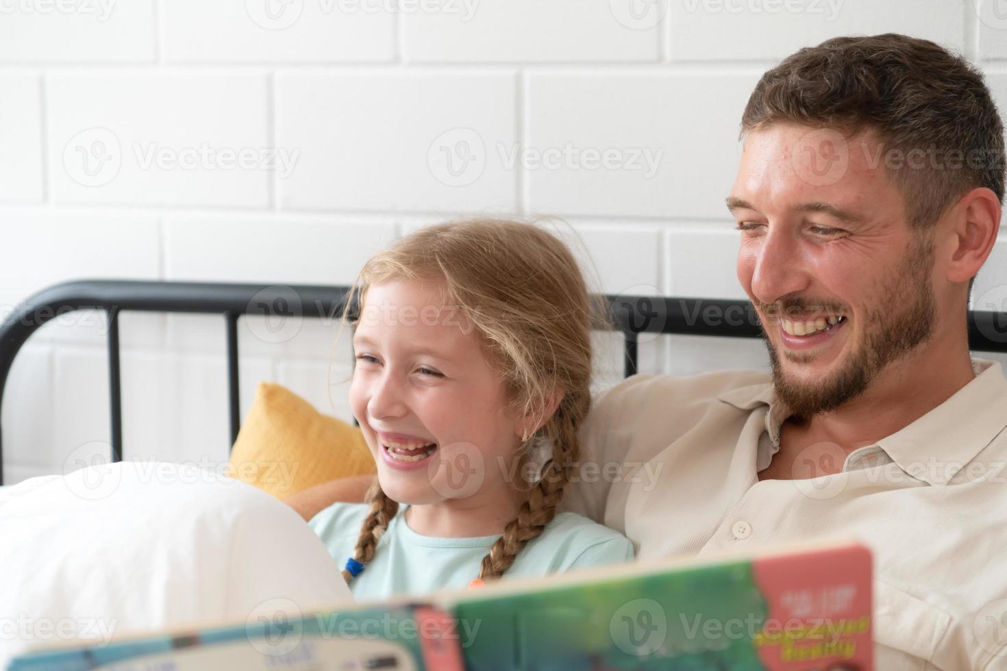 Little girl's father read stories to children before going to bed to unwind and sleep soundly until the morning. photo