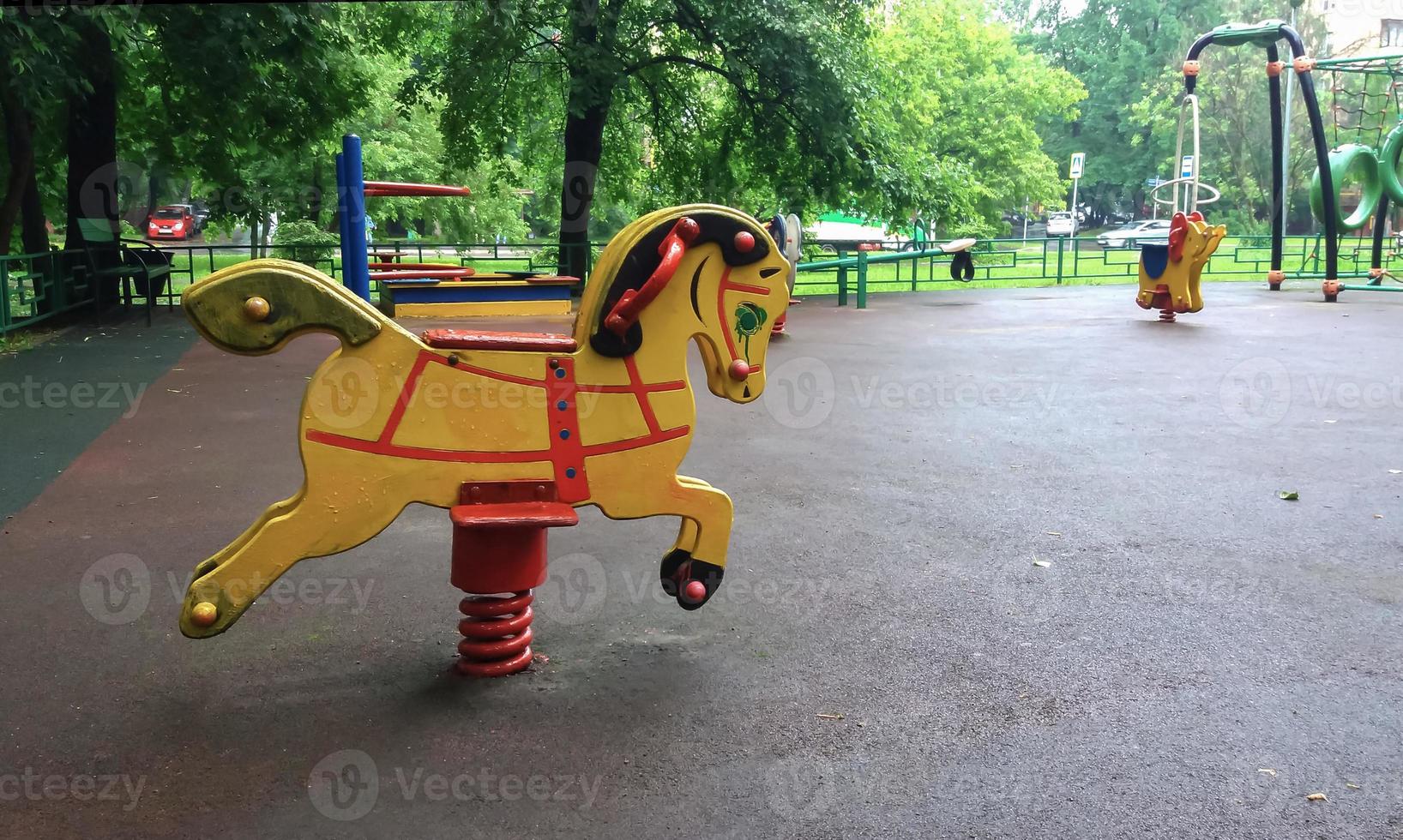 Empty kids playground in residential area, rocking horse in summer backyard photo