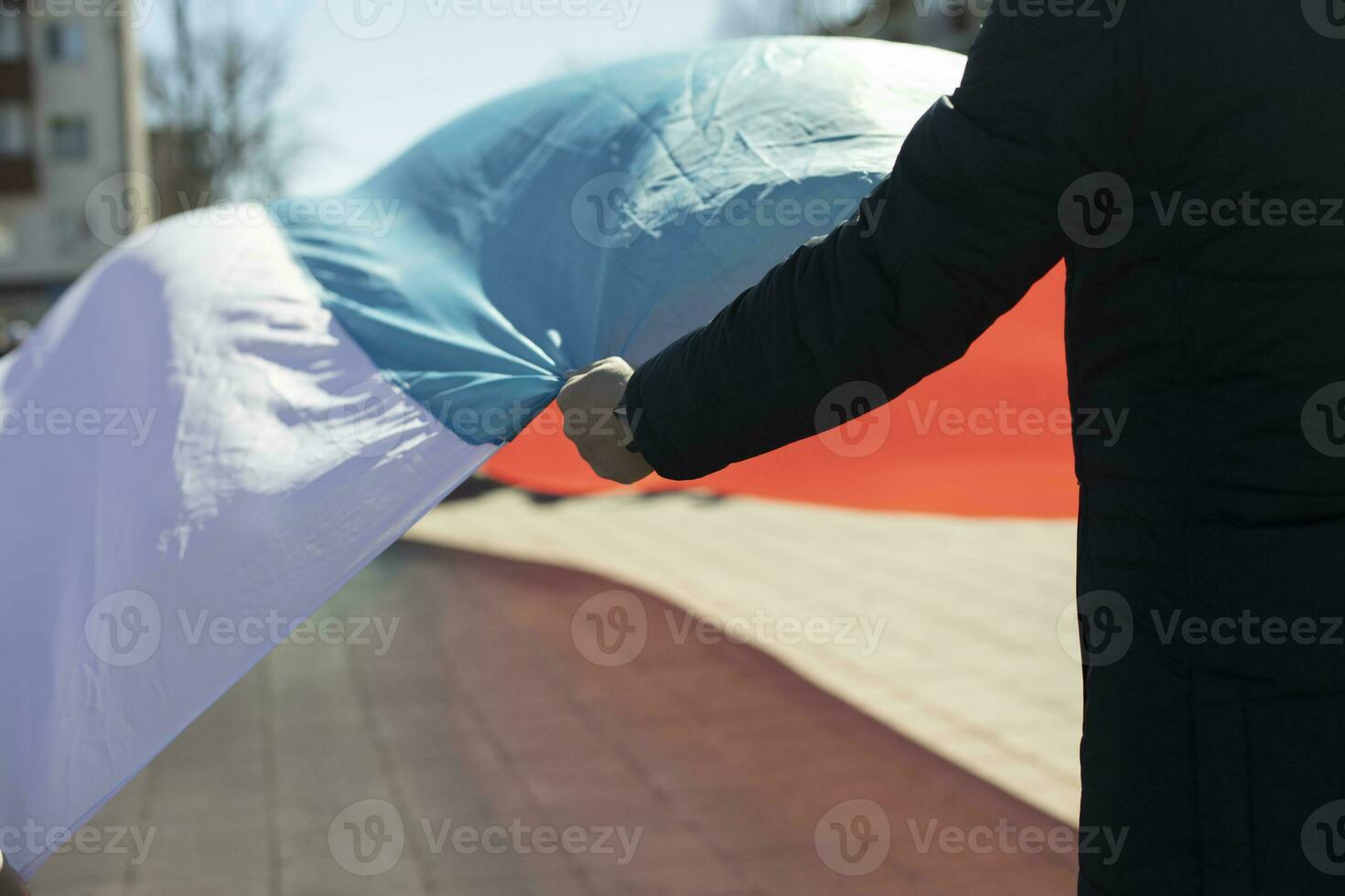 el hombre sostiene un paño. el hombre sostiene una gran bandera de rusia. foto