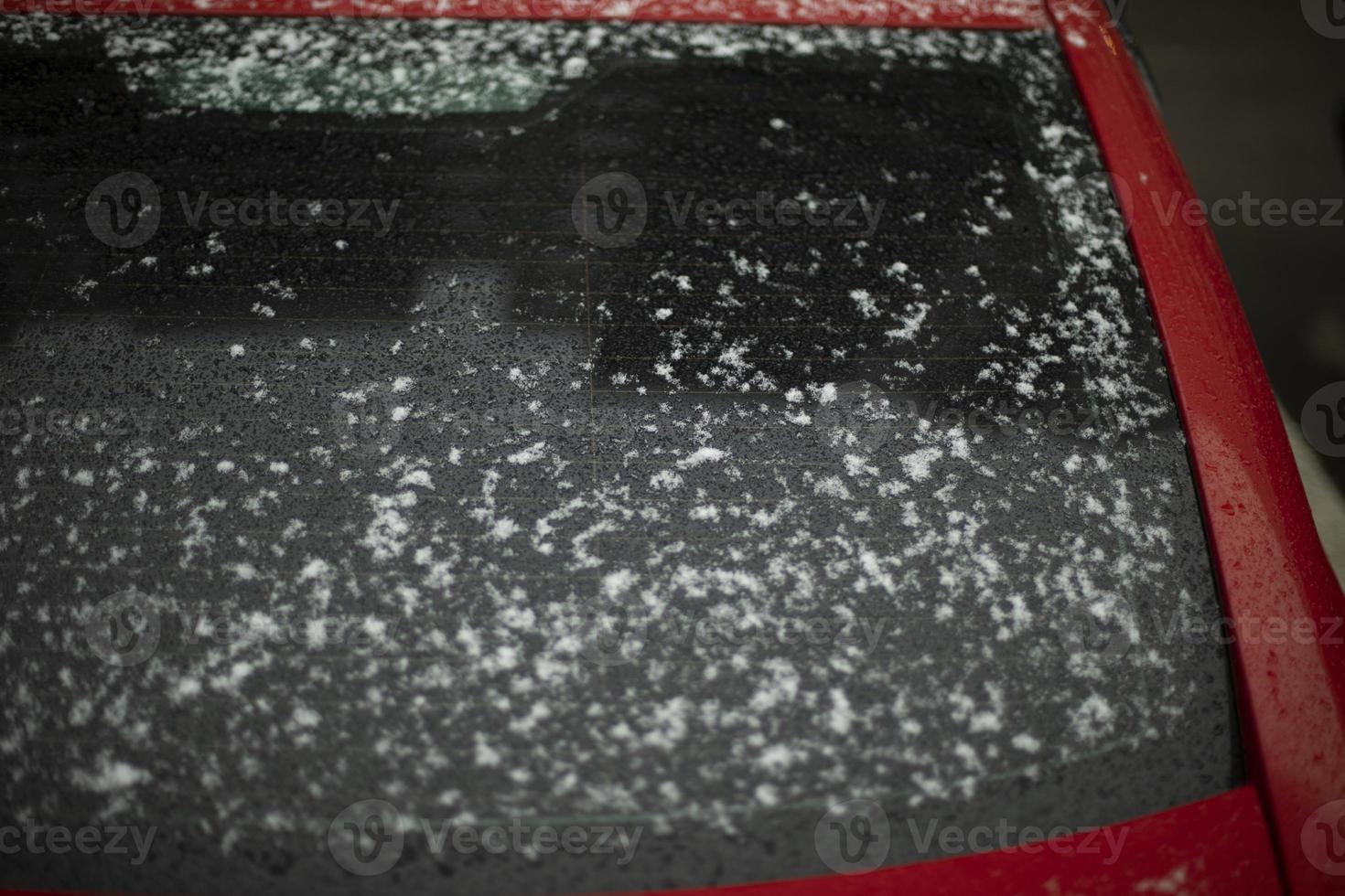 Red car in snow. Car body parts after precipitation. Car is parked in winter. photo