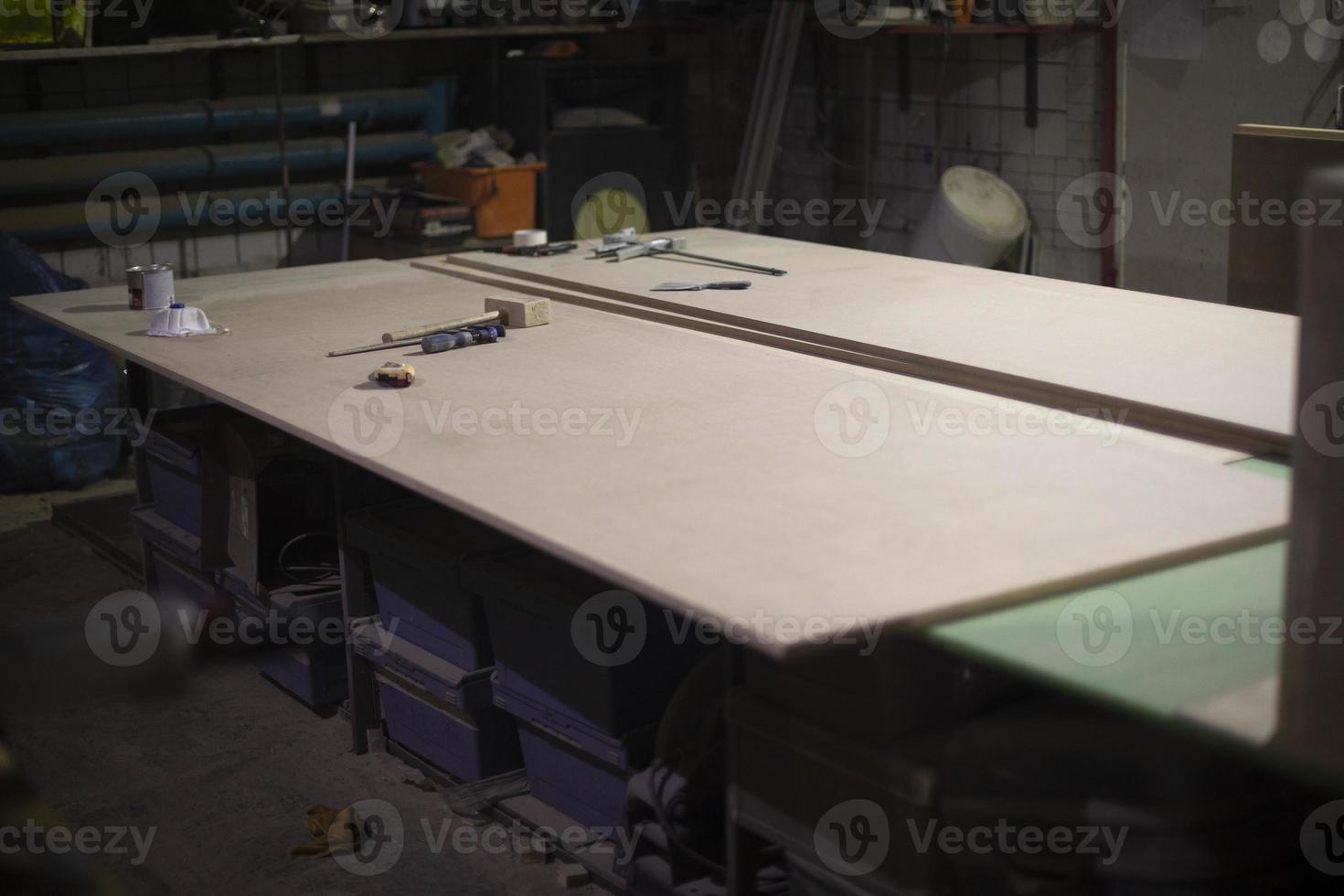 Table of workshop. Large board on table. Details of interior of working area. photo