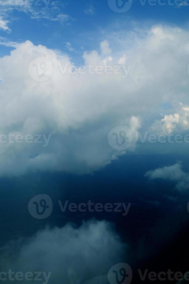 white clouds against the blue sky seen from the flight from the windows of the plane photo