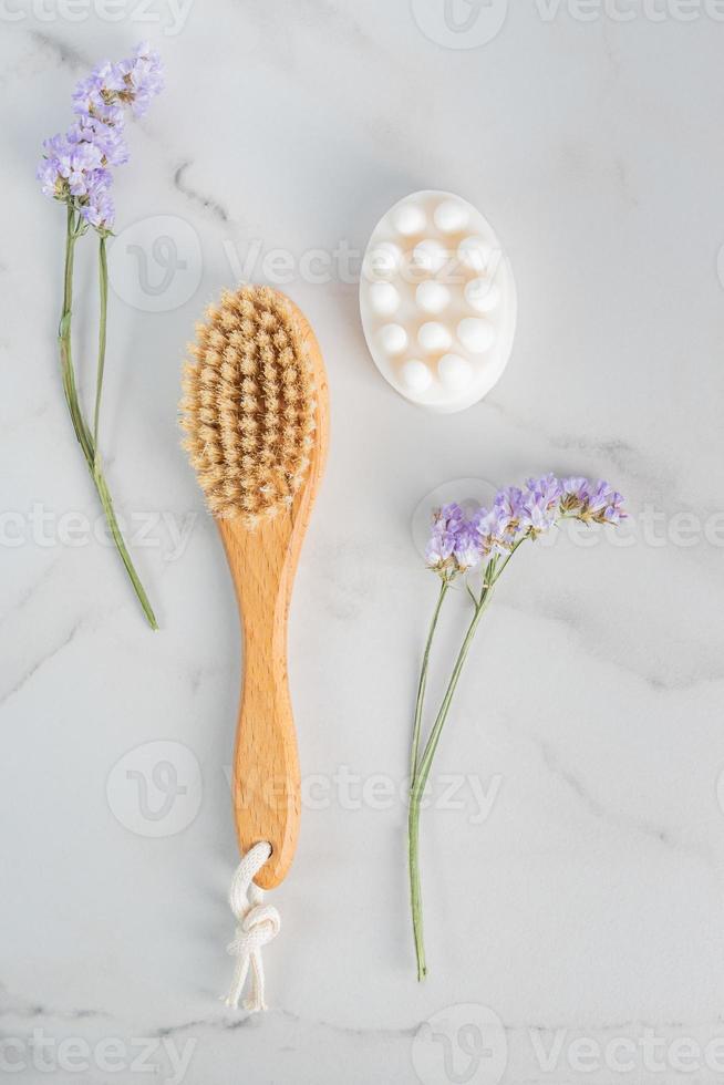 lleno cuerpo seco masaje cepillo y hecho a mano miel jabón desde encima en mármol antecedentes con púrpura flores foto
