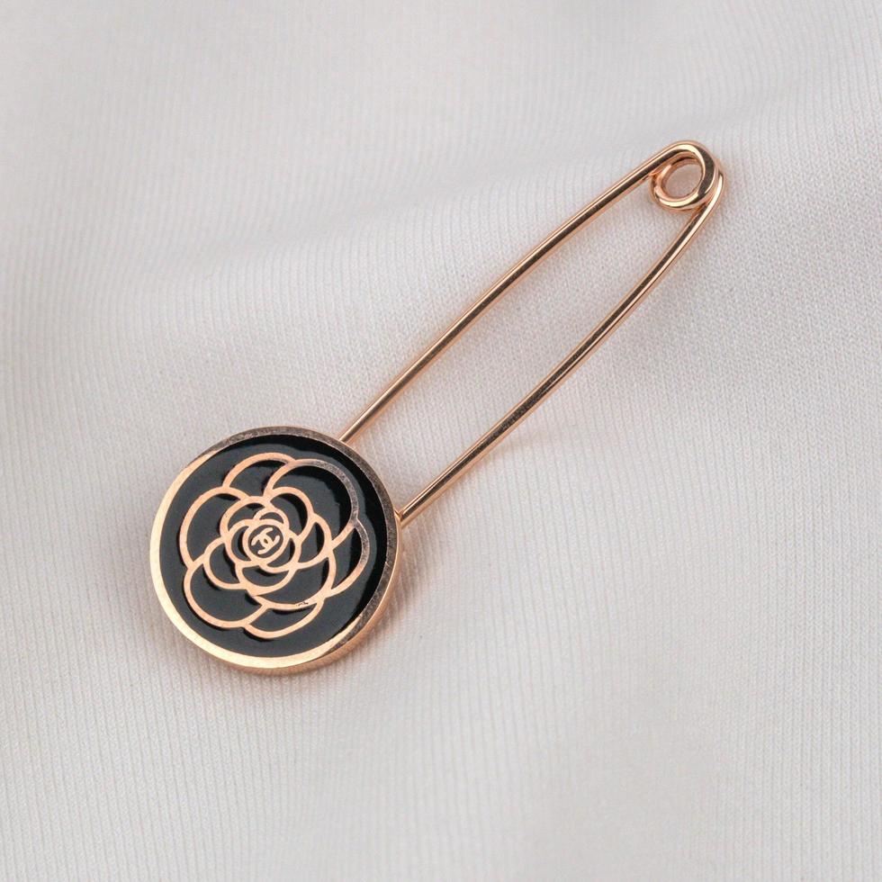gold pin with black flower photo
