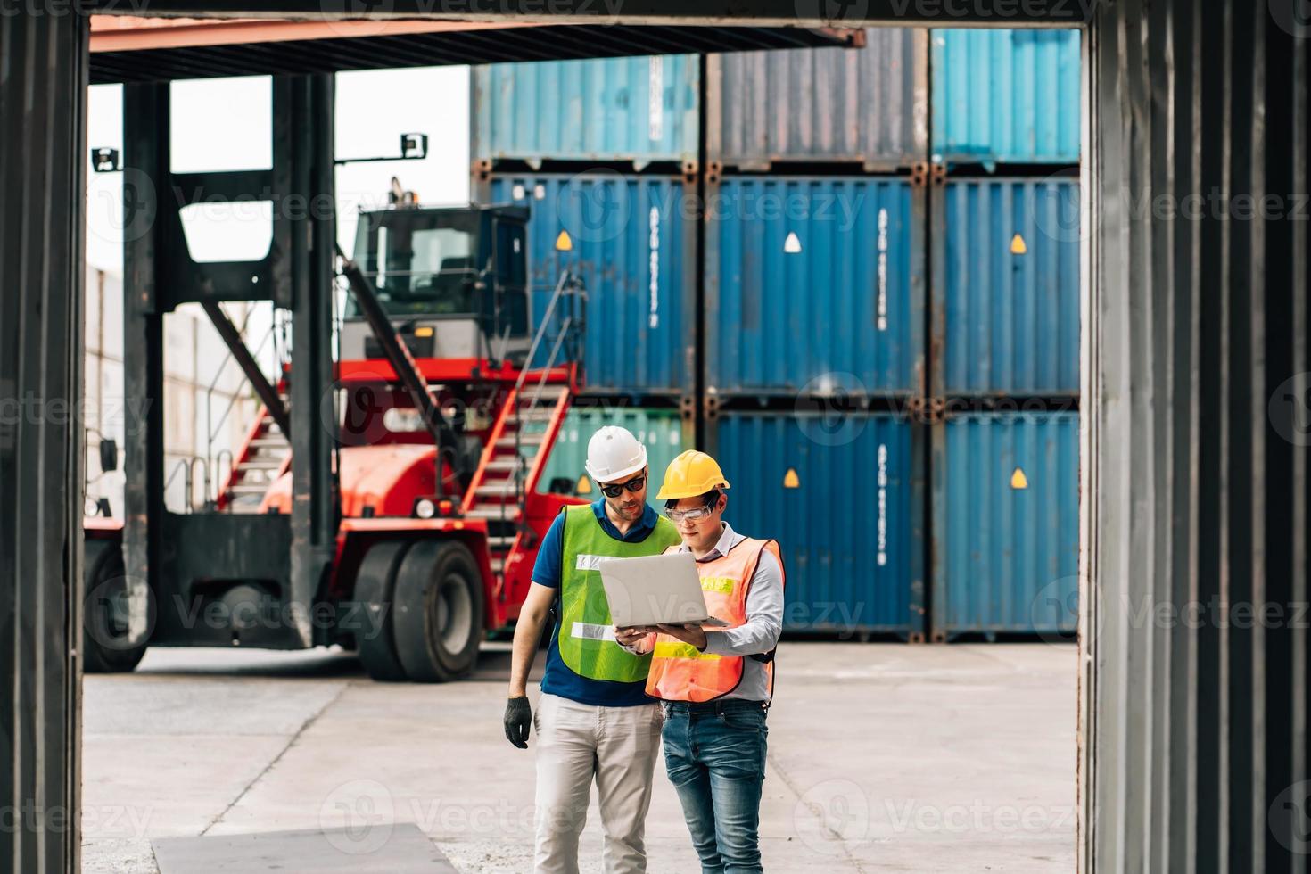 Team Engineer and worker wear safety uniform check control loading freight cargo container use computer laptop at commercial dock warehouse,transportation import,export logistic industrial service photo
