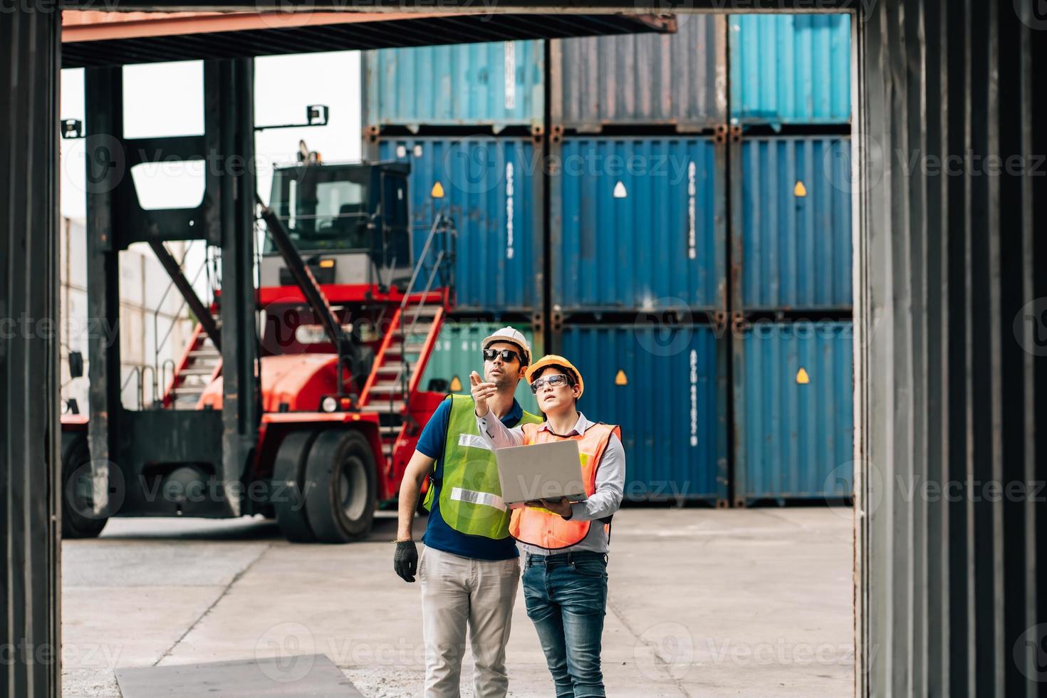 Team Engineer and worker wear safety uniform check control loading freight cargo container use computer laptop at commercial dock warehouse,transportation import,export logistic industrial service photo