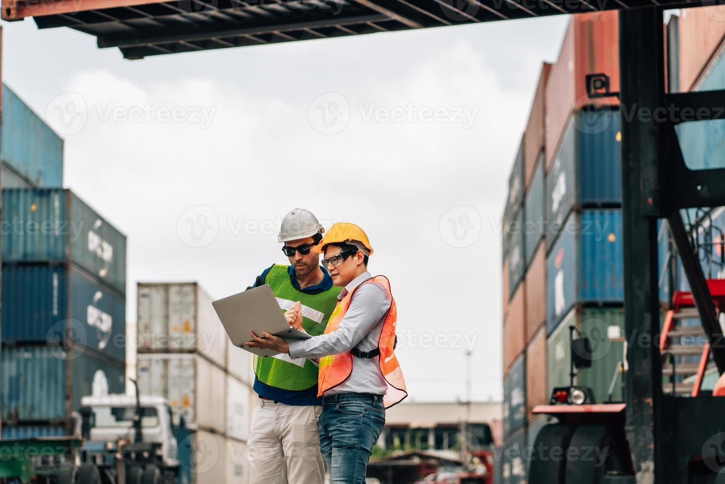 Team Engineer and worker wear safety uniform check control loading freight cargo container use computer laptop at commercial dock warehouse,transportation import,export logistic industrial service photo