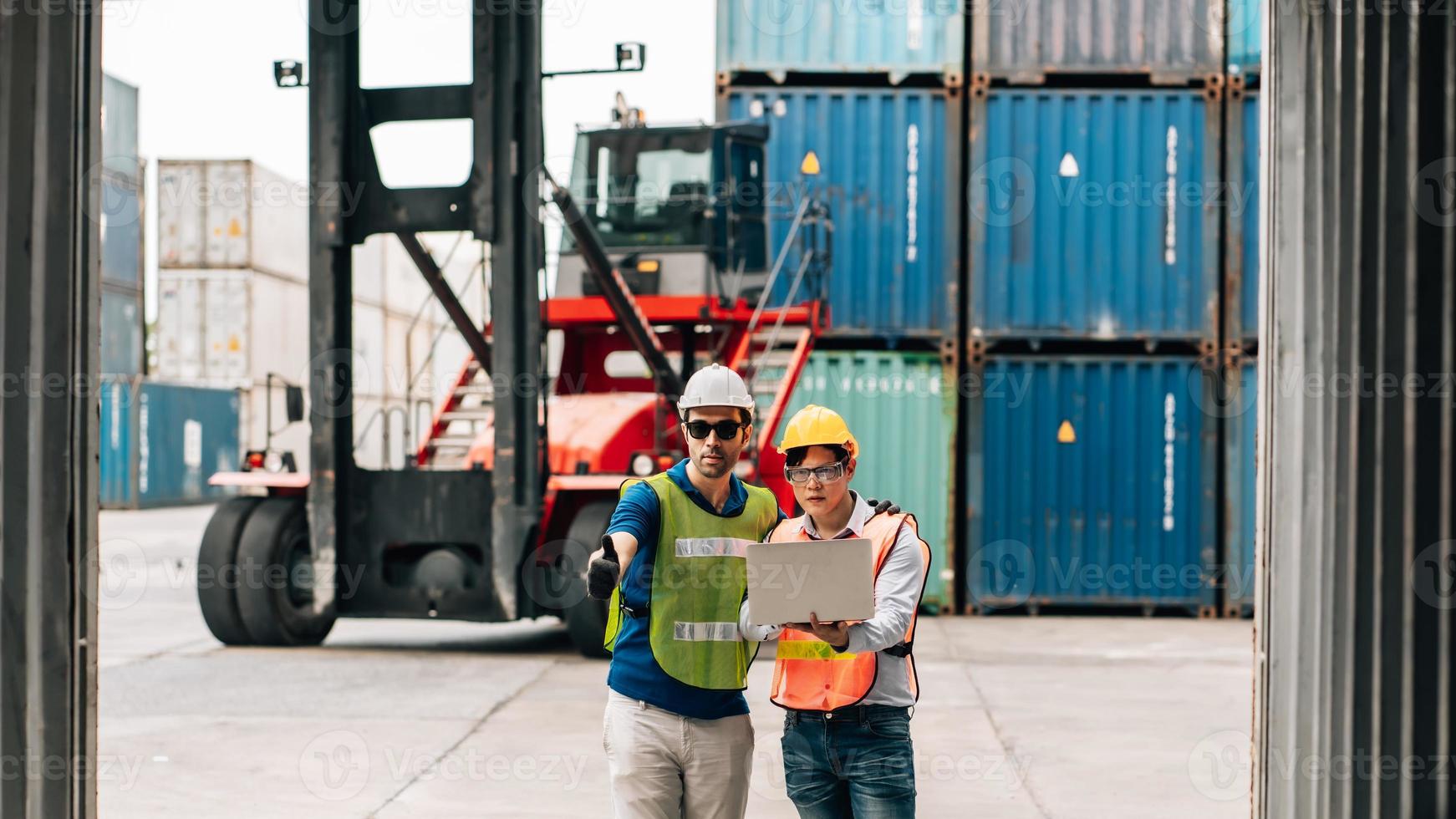 Team Engineer and worker wear safety uniform check control loading freight cargo container use computer laptop at commercial dock warehouse,transportation import,export logistic industrial service photo
