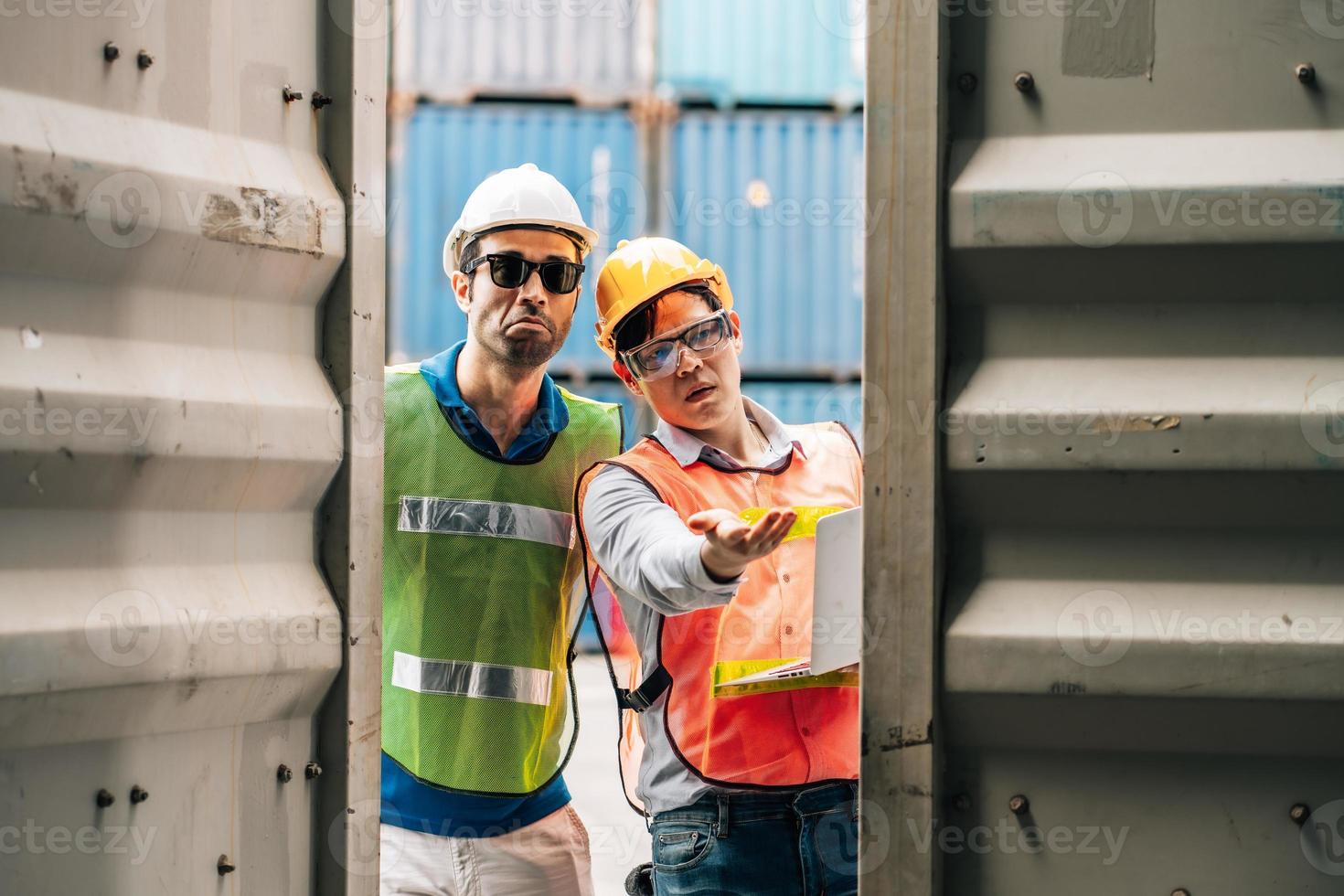 Team Engineer and worker wear safety uniform check control loading freight cargo container use computer laptop at commercial dock warehouse,transportation import,export logistic industrial service photo
