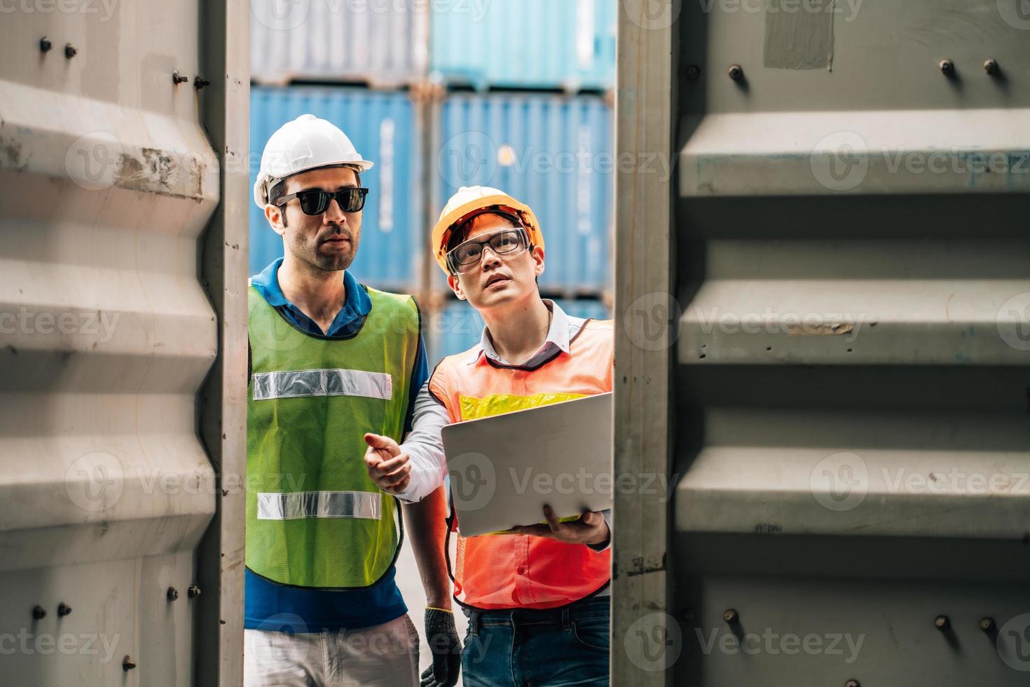 Team Engineer and worker wear safety uniform check control loading freight cargo container use computer laptop at commercial dock warehouse,transportation import,export logistic industrial service photo