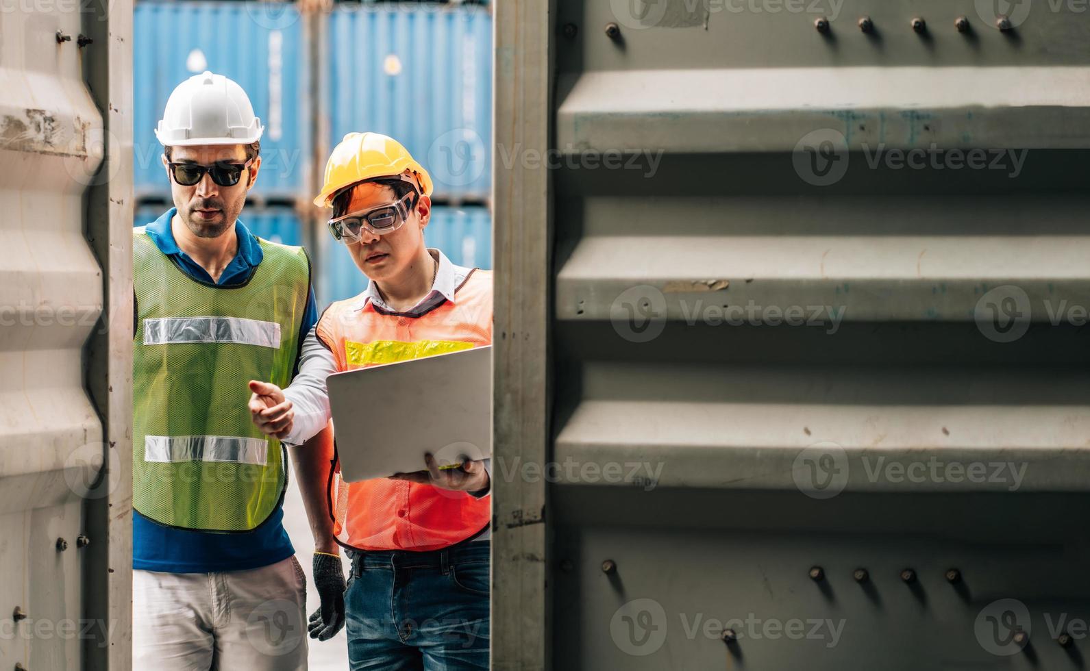 Team Engineer and worker wear safety uniform check control loading freight cargo container use computer laptop at commercial dock warehouse,transportation import,export logistic industrial service photo