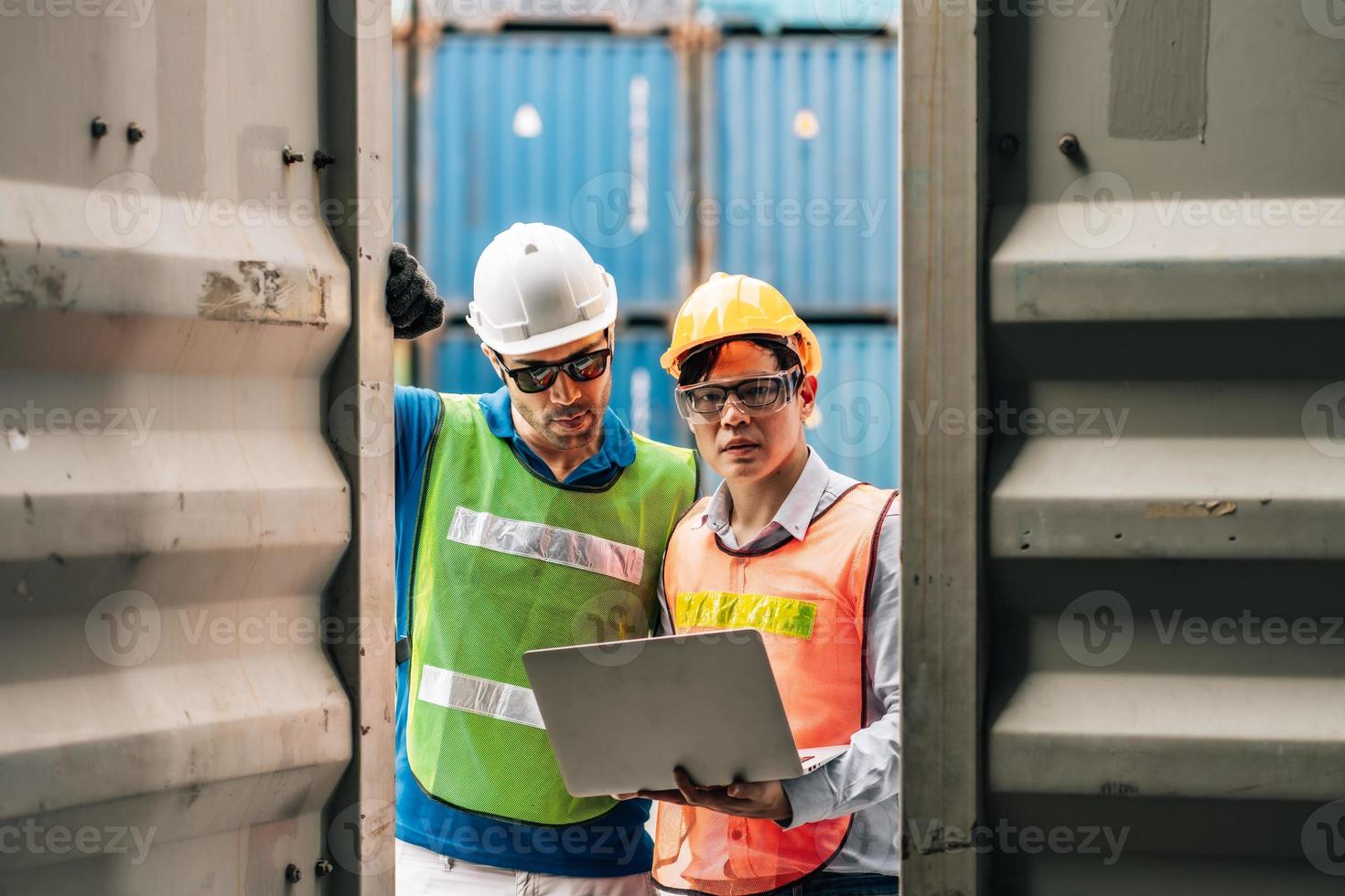 Team Engineer and worker wear safety uniform check control loading freight cargo container use computer laptop at commercial dock warehouse,transportation import,export logistic industrial service photo
