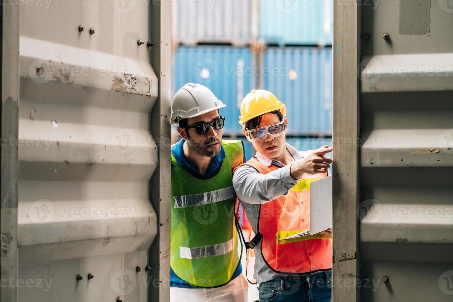 Team Engineer and worker wear safety uniform check control loading freight cargo container use computer laptop at commercial dock warehouse,transportation import,export logistic industrial service photo