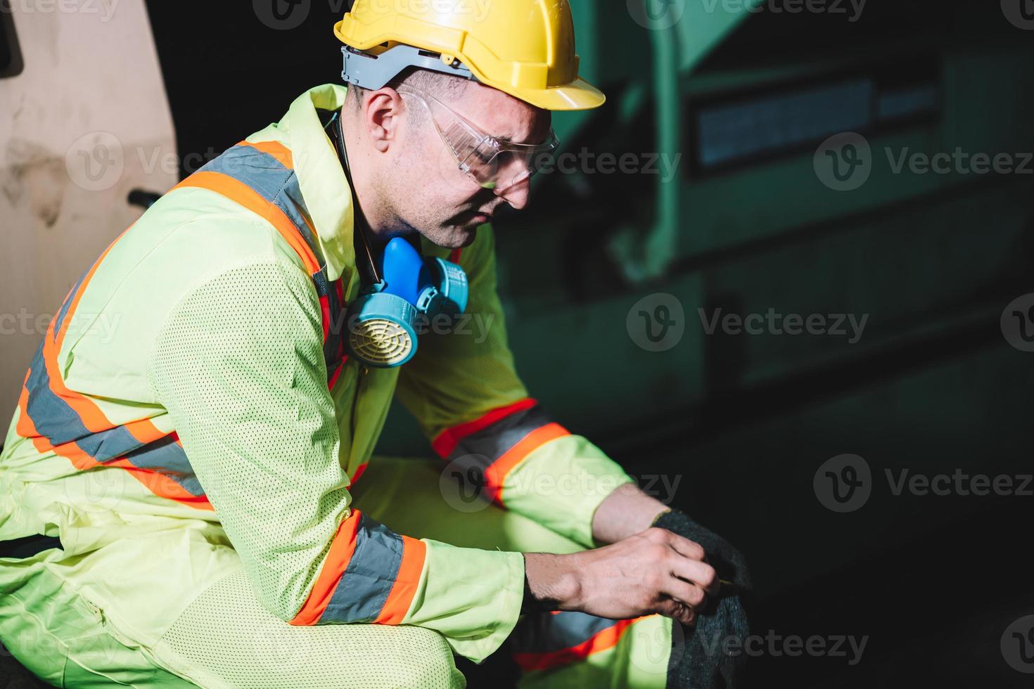 Portrait of factory worker man wearing hardhat and safety protection sitting in gloves to prepare for work photo